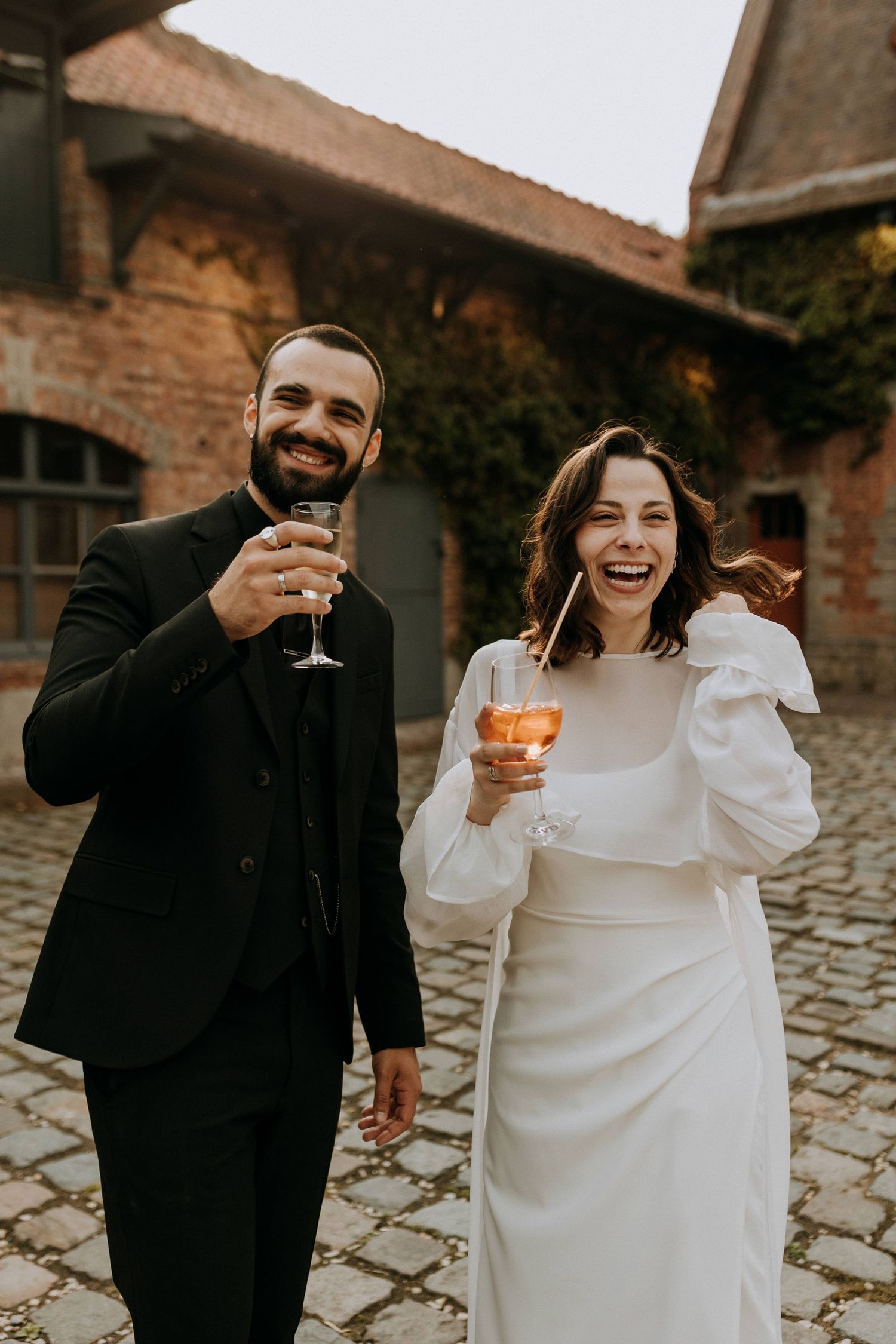 Couple de mariés marchant et riant, photographie de mariage naturelle en reportage
