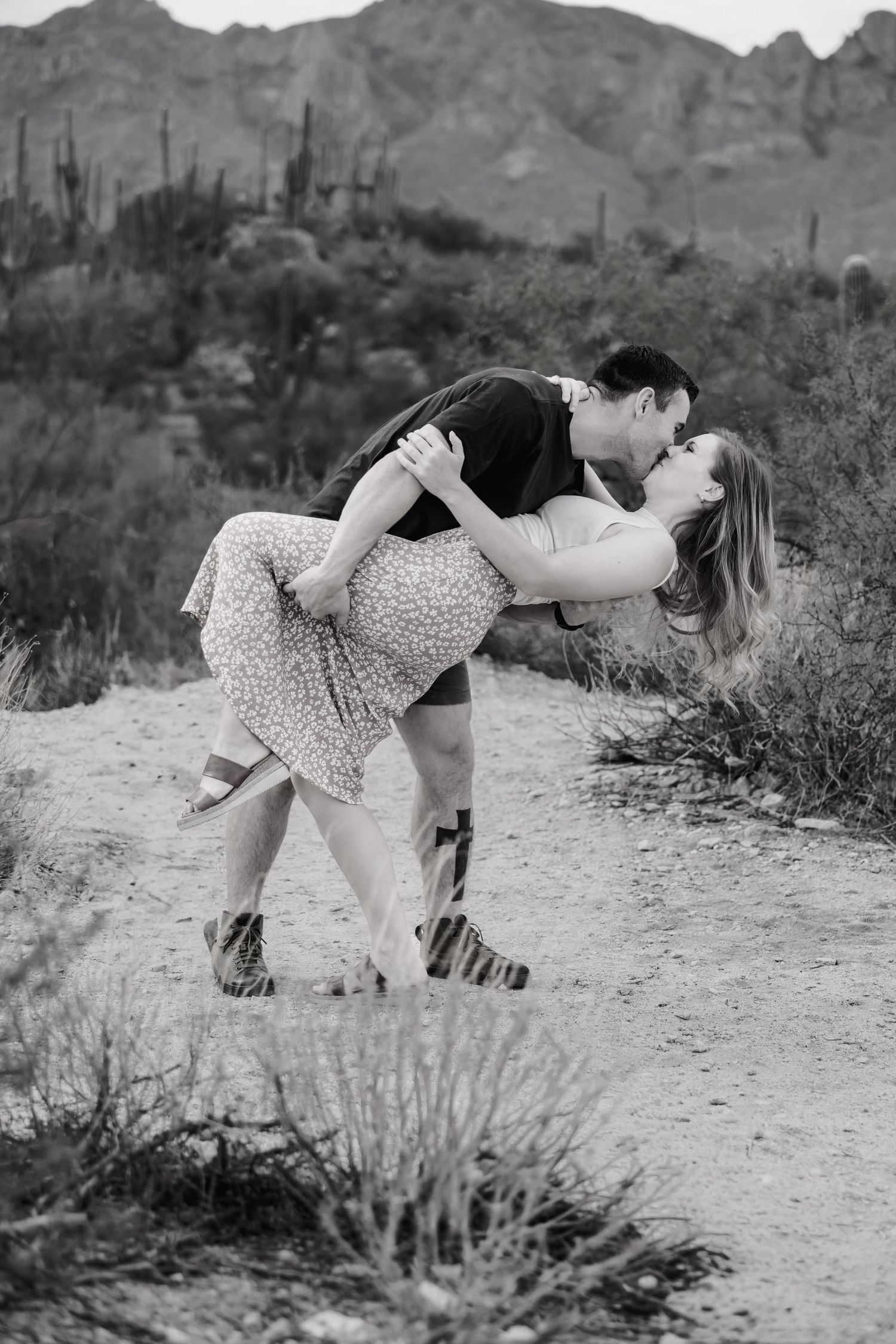 A romantic black and white photo sequence shows a couple dancing and dipping in a desert landscape with mountains.