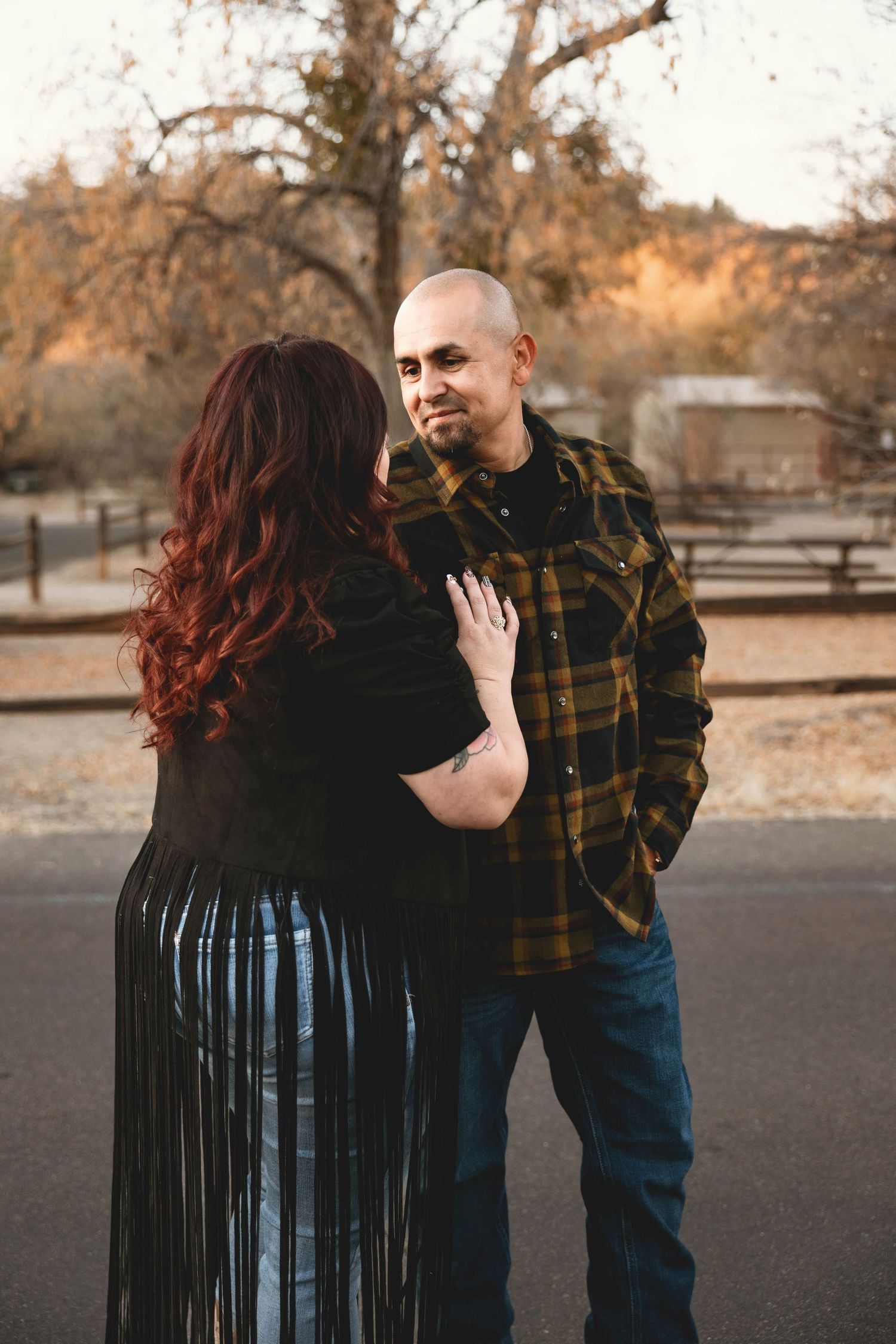 A couple shares a romantic moment in a series of candid photos at sunset in a park setting.