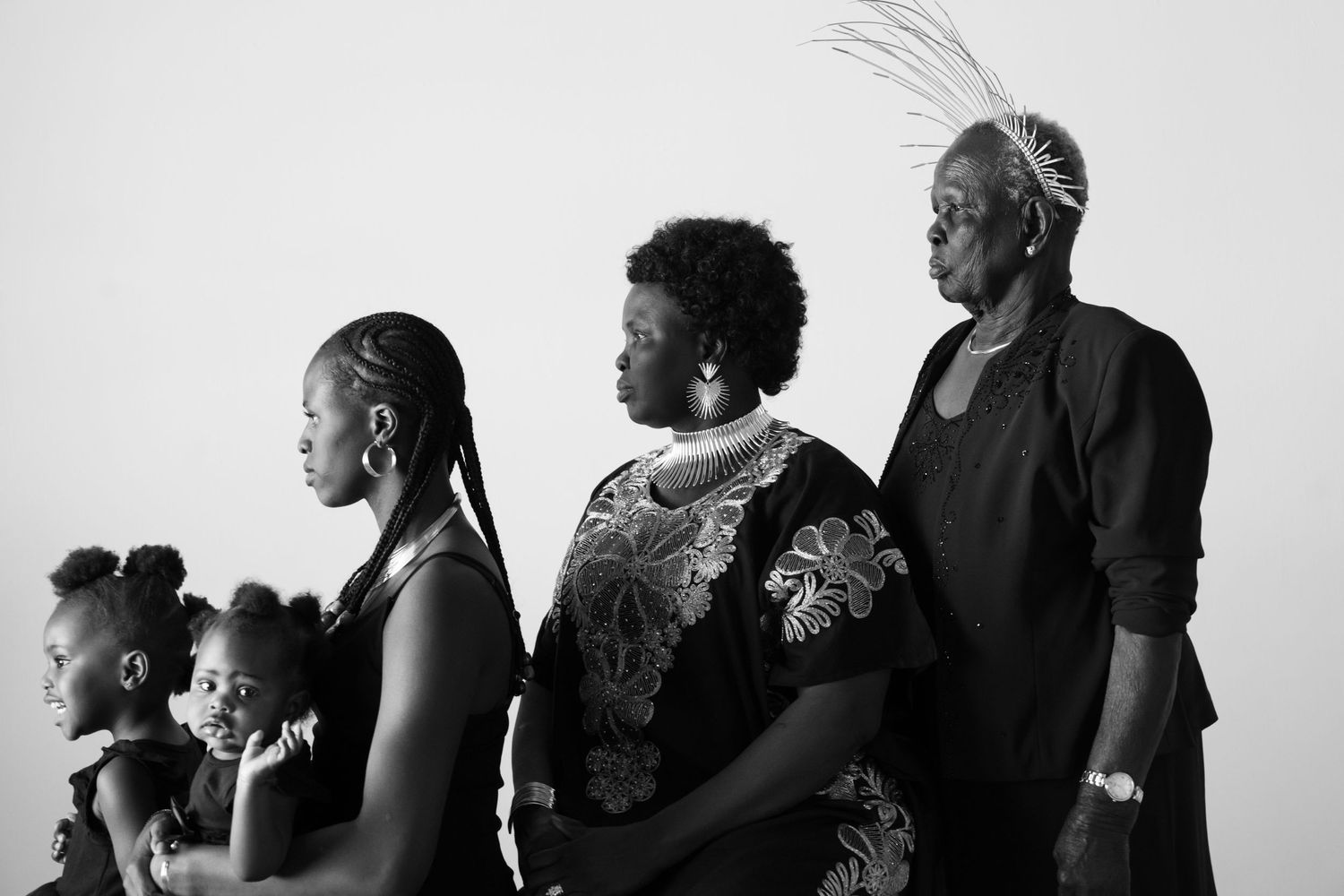 Black and white profile silhouettes of a family group against a white background.