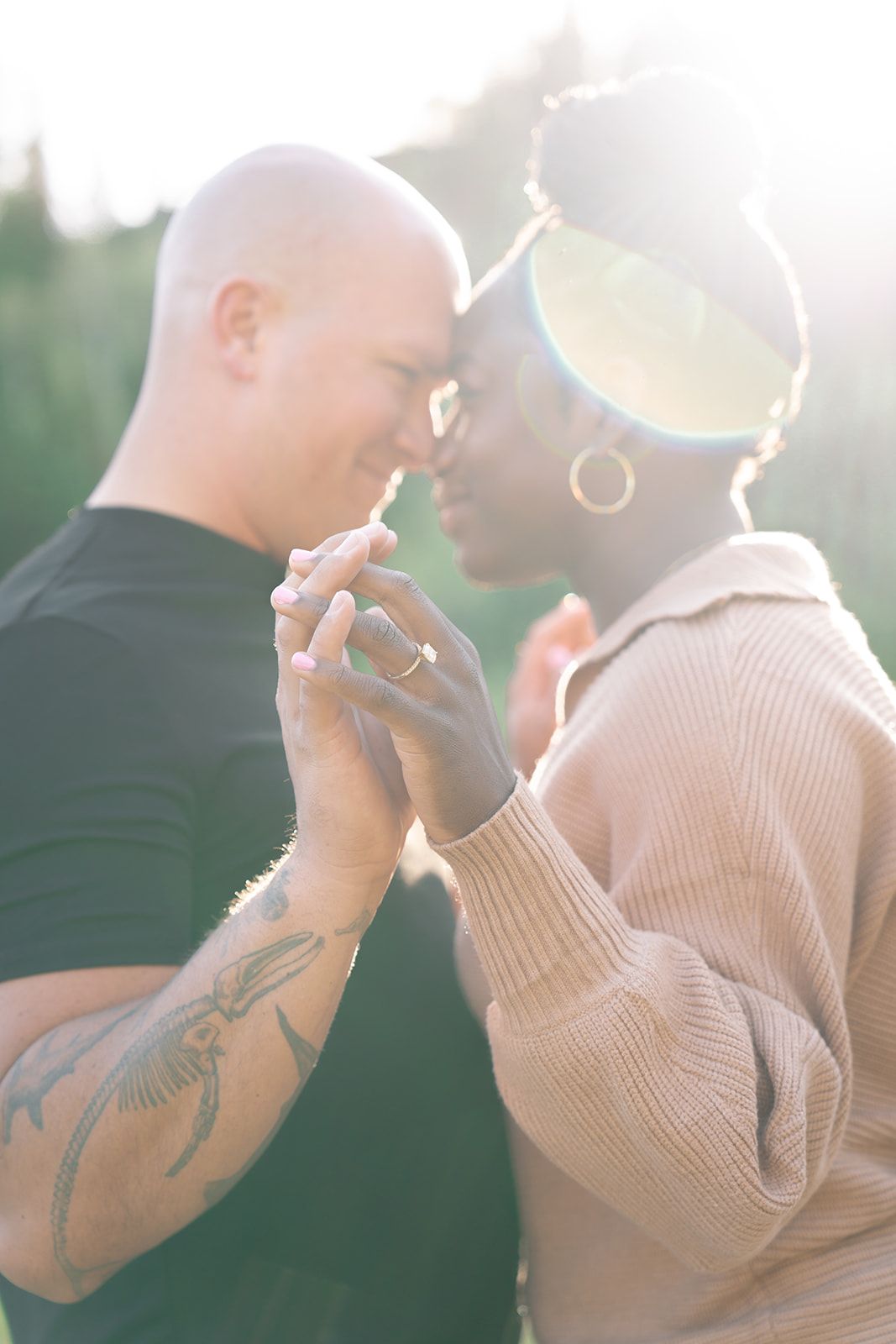 Intimate couple moment backlit by golden sunlight showing tender connection.