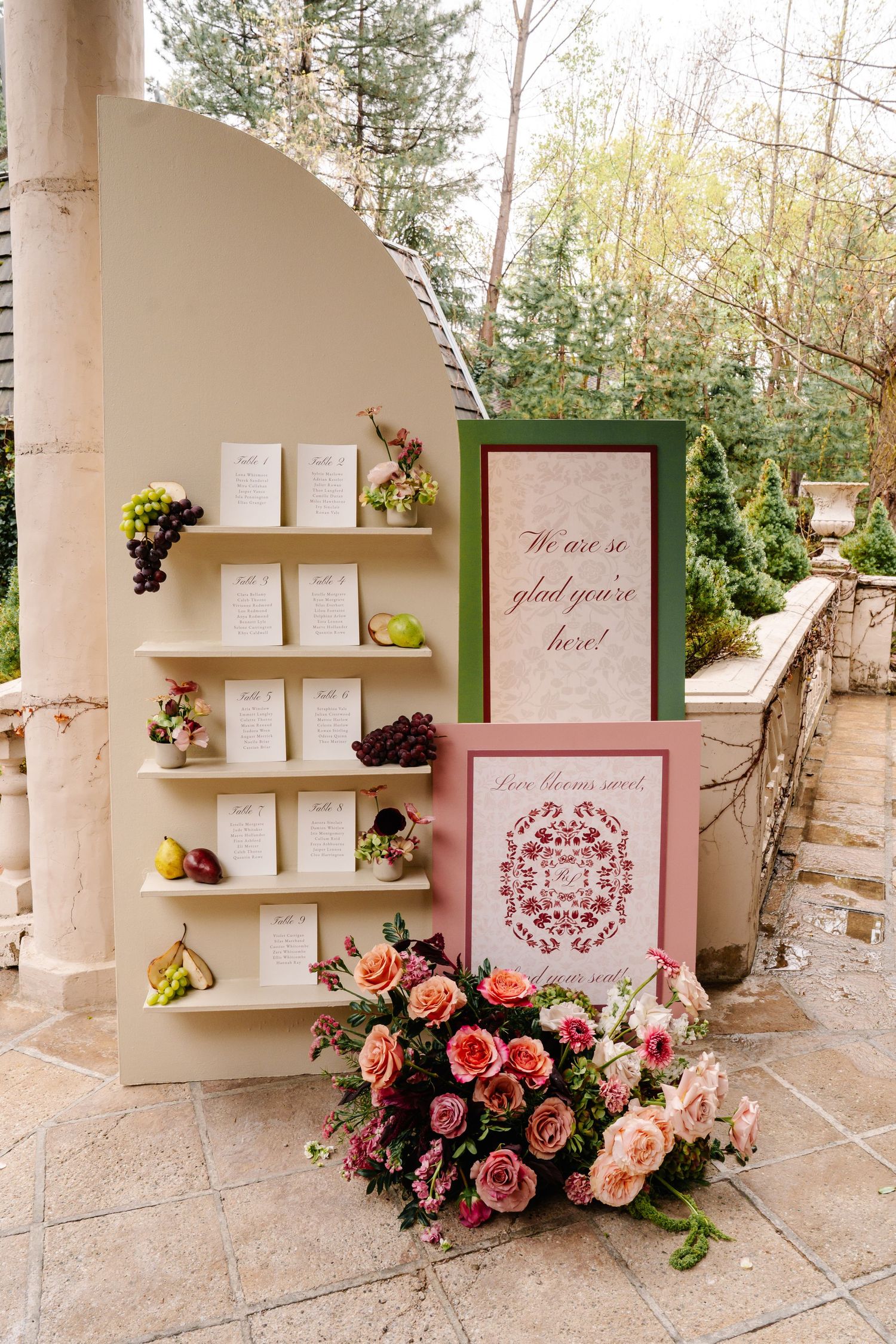 Wedding decorations featuring pink roses and framed displays on rustic shelves.
