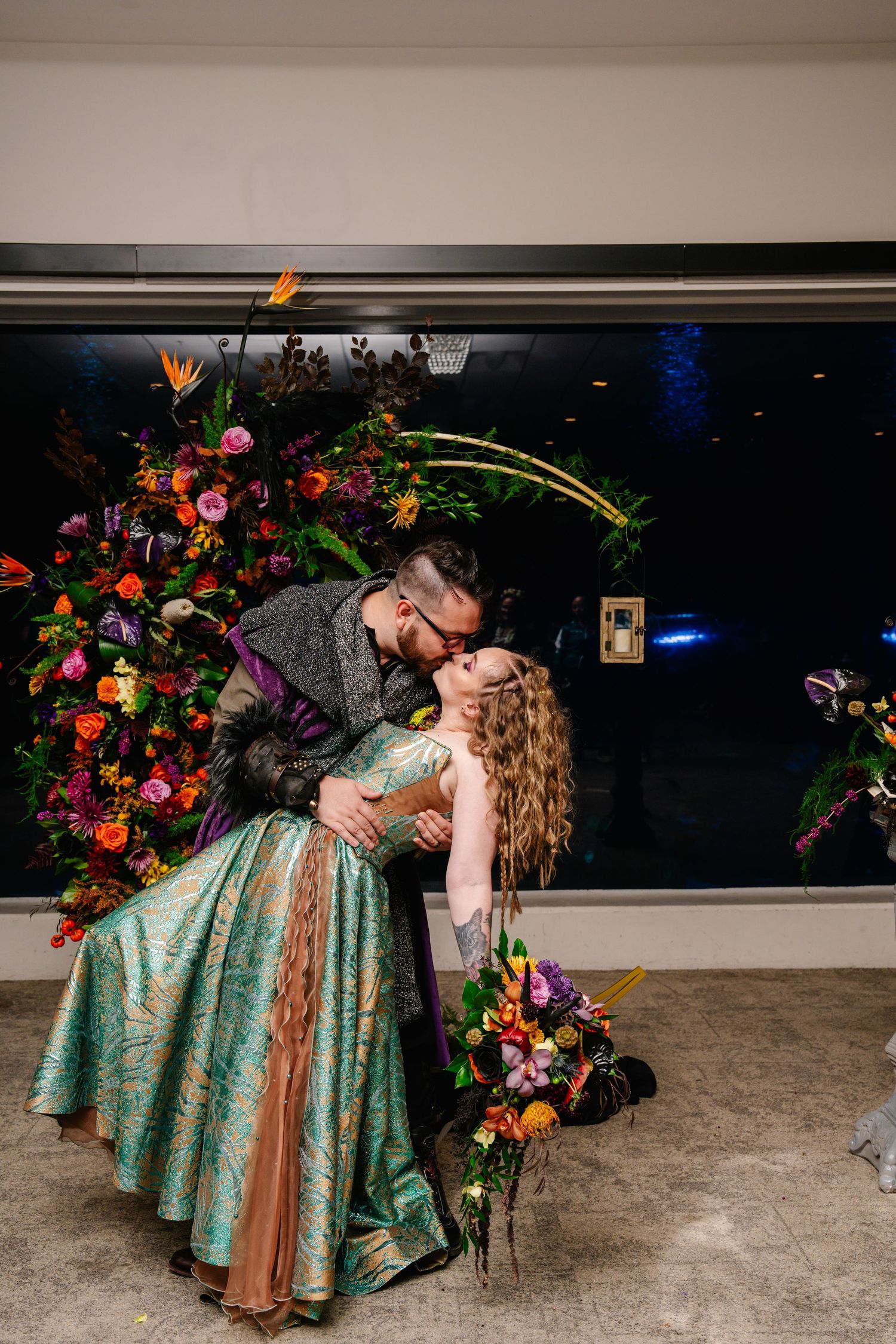 Romantic scene with couple posed dramatically against colorful floral backdrop.