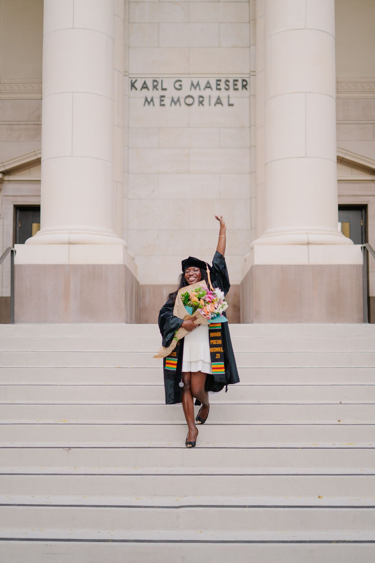 Graduation celebration at Karl G Maeser Memorial with joyful poses on white steps.