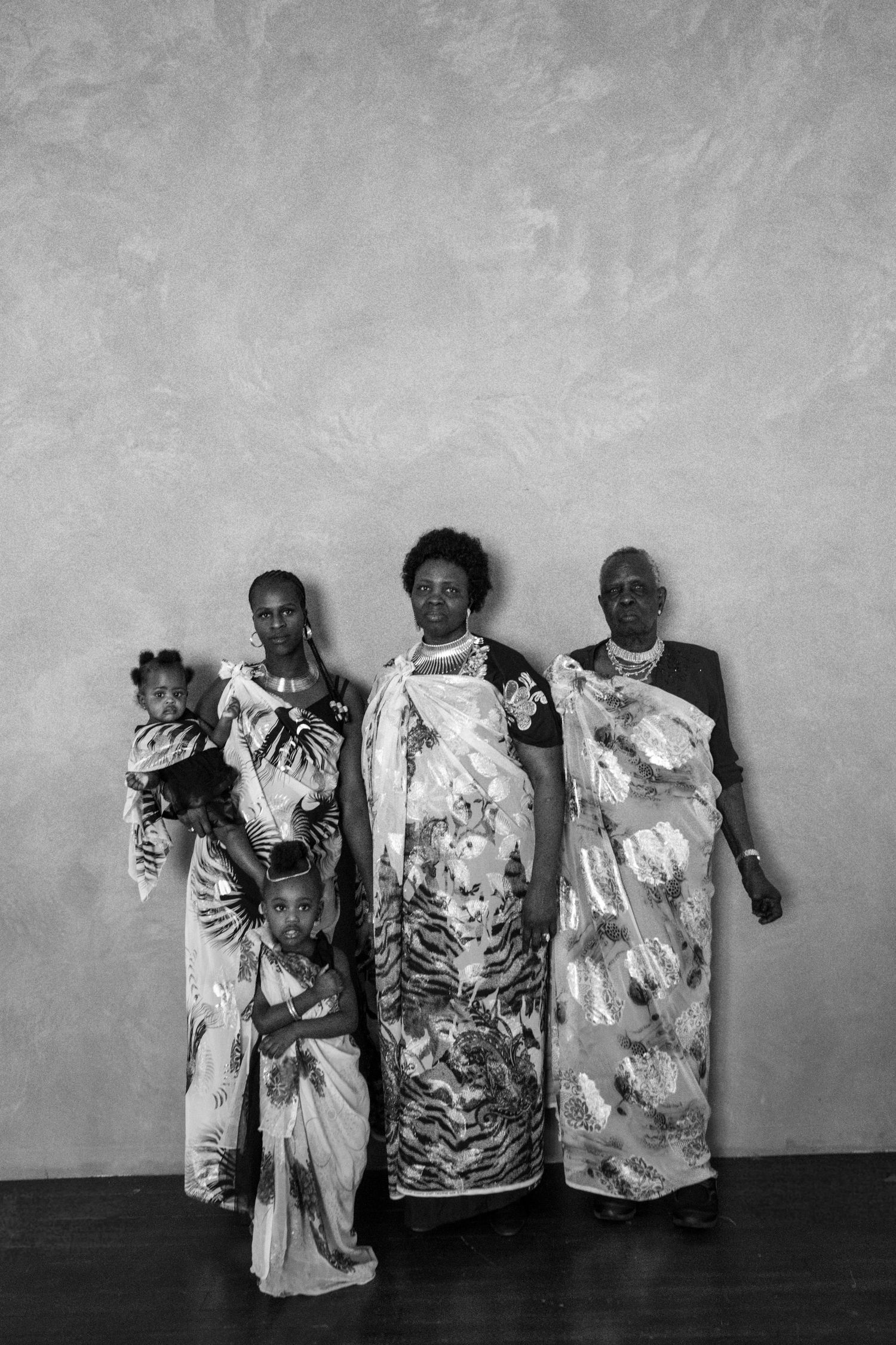Black and white artistic display of tie-dye patterned clothing against a wall.