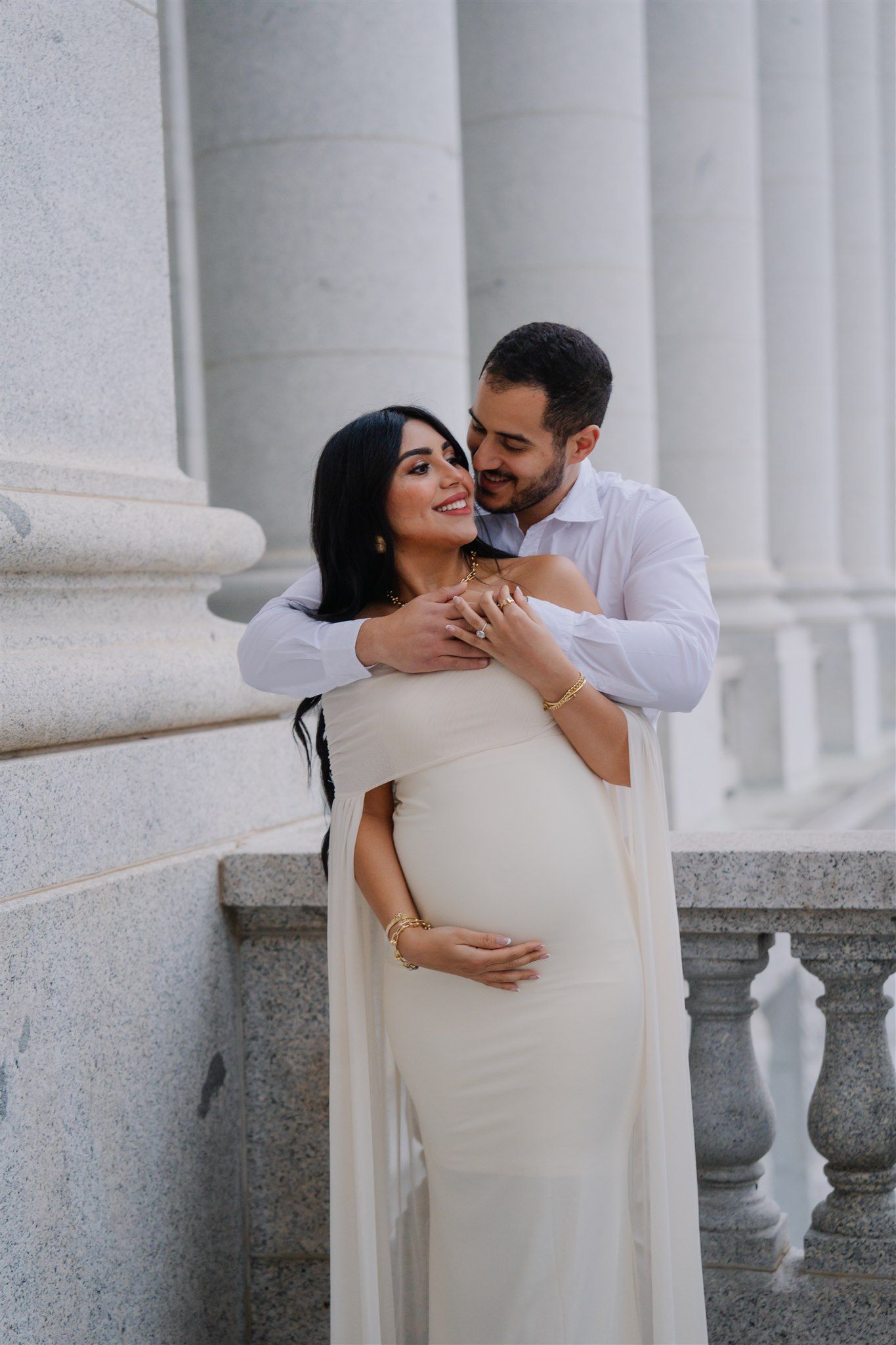 Romantic maternity photos captured against white classical columns.