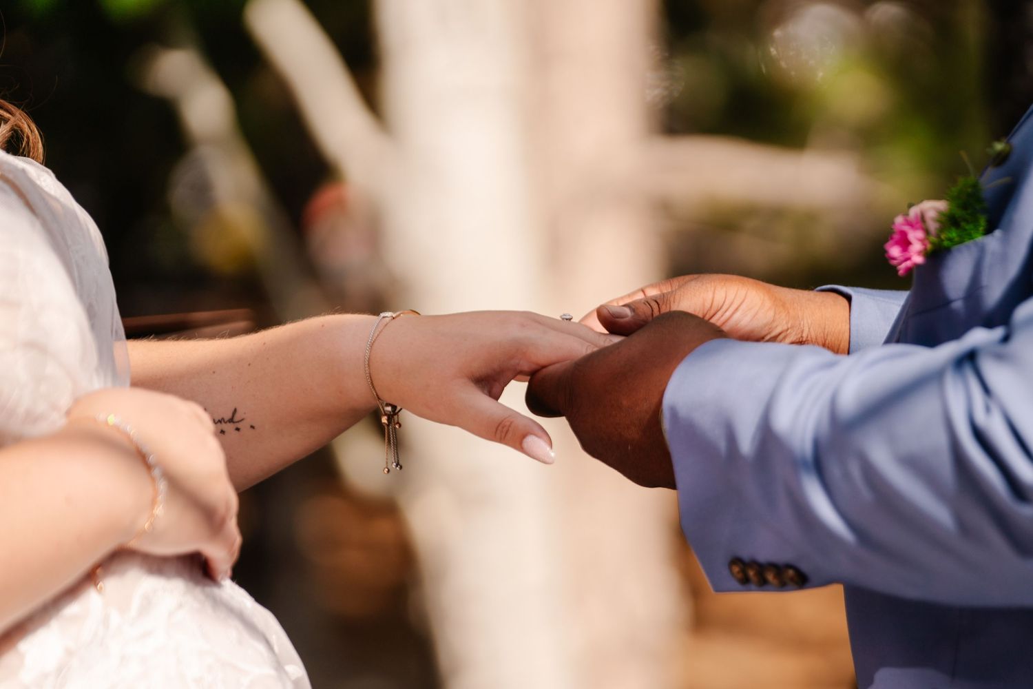 Close-up shot of hands exchanging wedding rings during a ceremony.