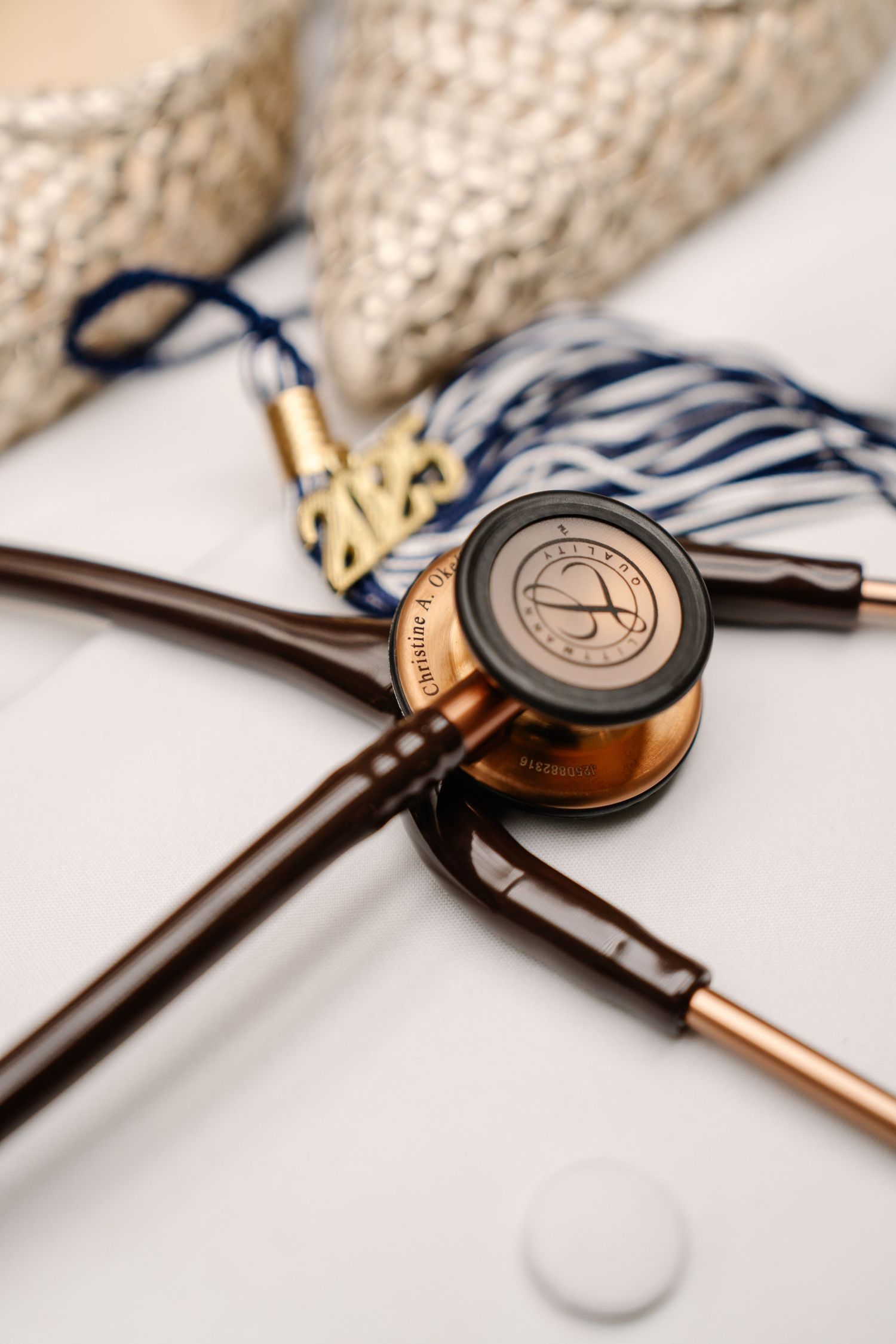Close-up of a copper and bronze stethoscope with medical equipment on a textured surface.