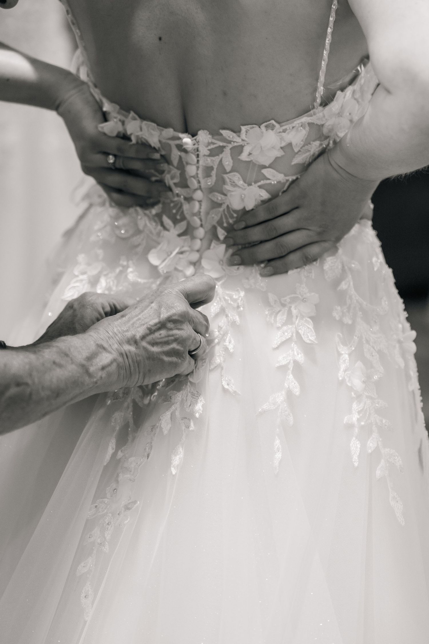 Close-up details of delicate lace appliques and beading on a white wedding gown.