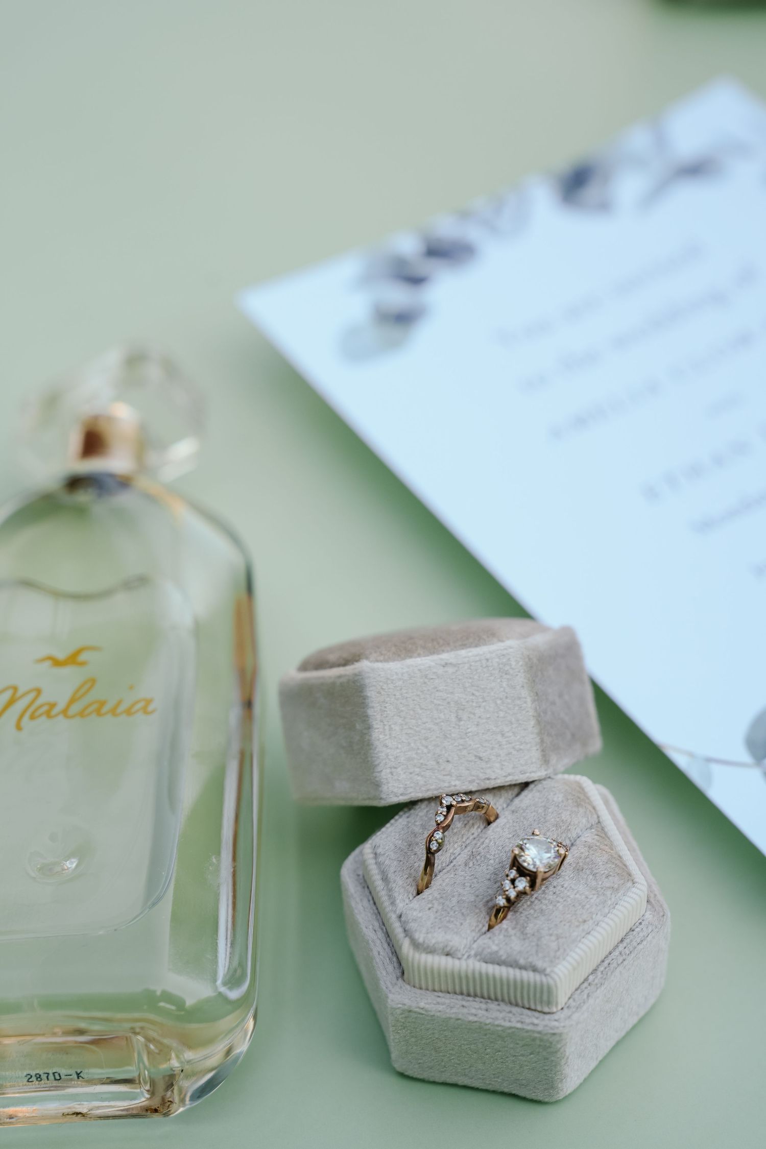Wedding rings and jewelry displayed in elegant velvet ring boxes with invitation cards.