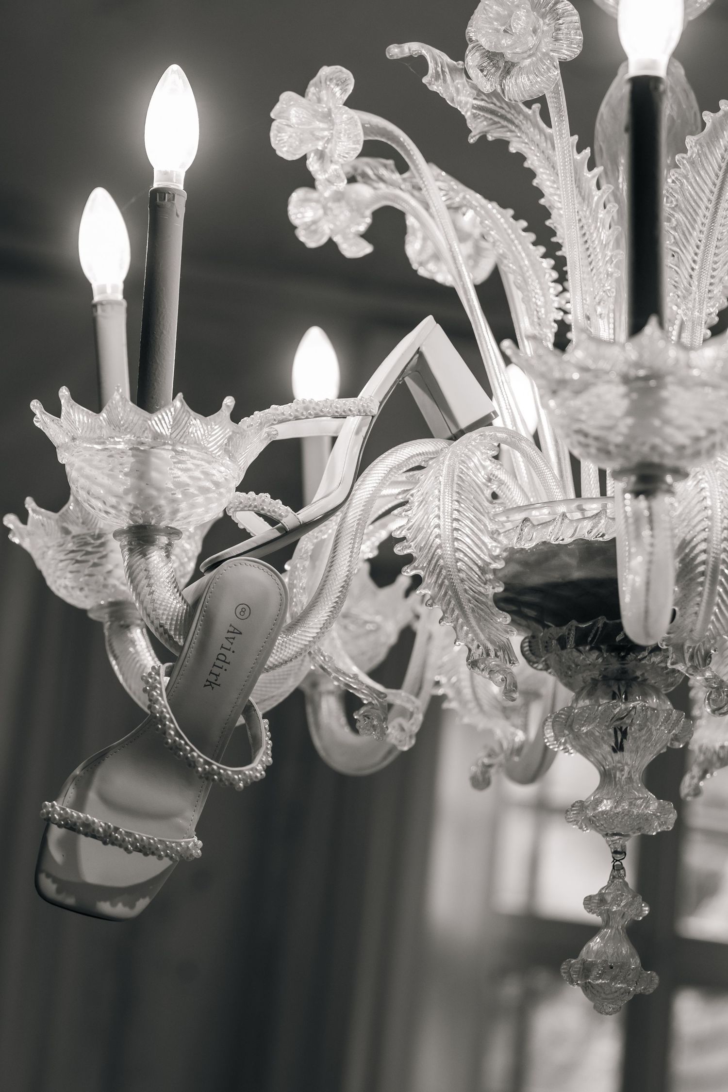 Ornate crystal chandelier with multiple white glass details and candle-style lights.