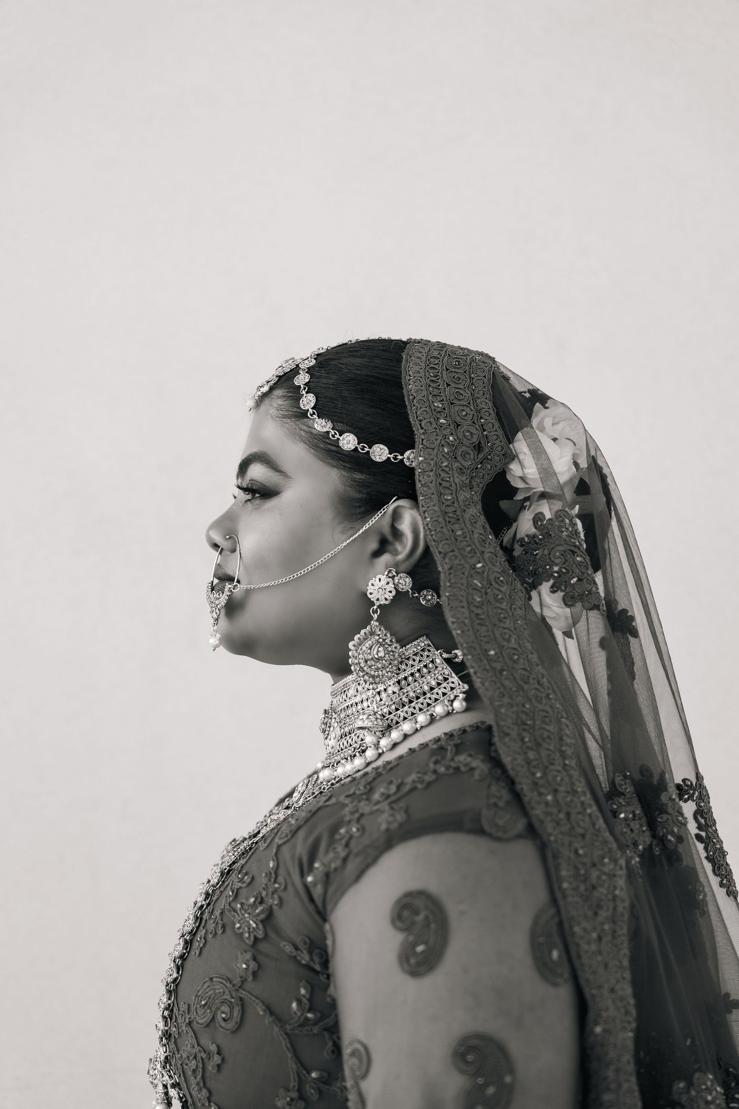Artistic black and white profile portraits of a bride wearing traditional Indian jewelry.