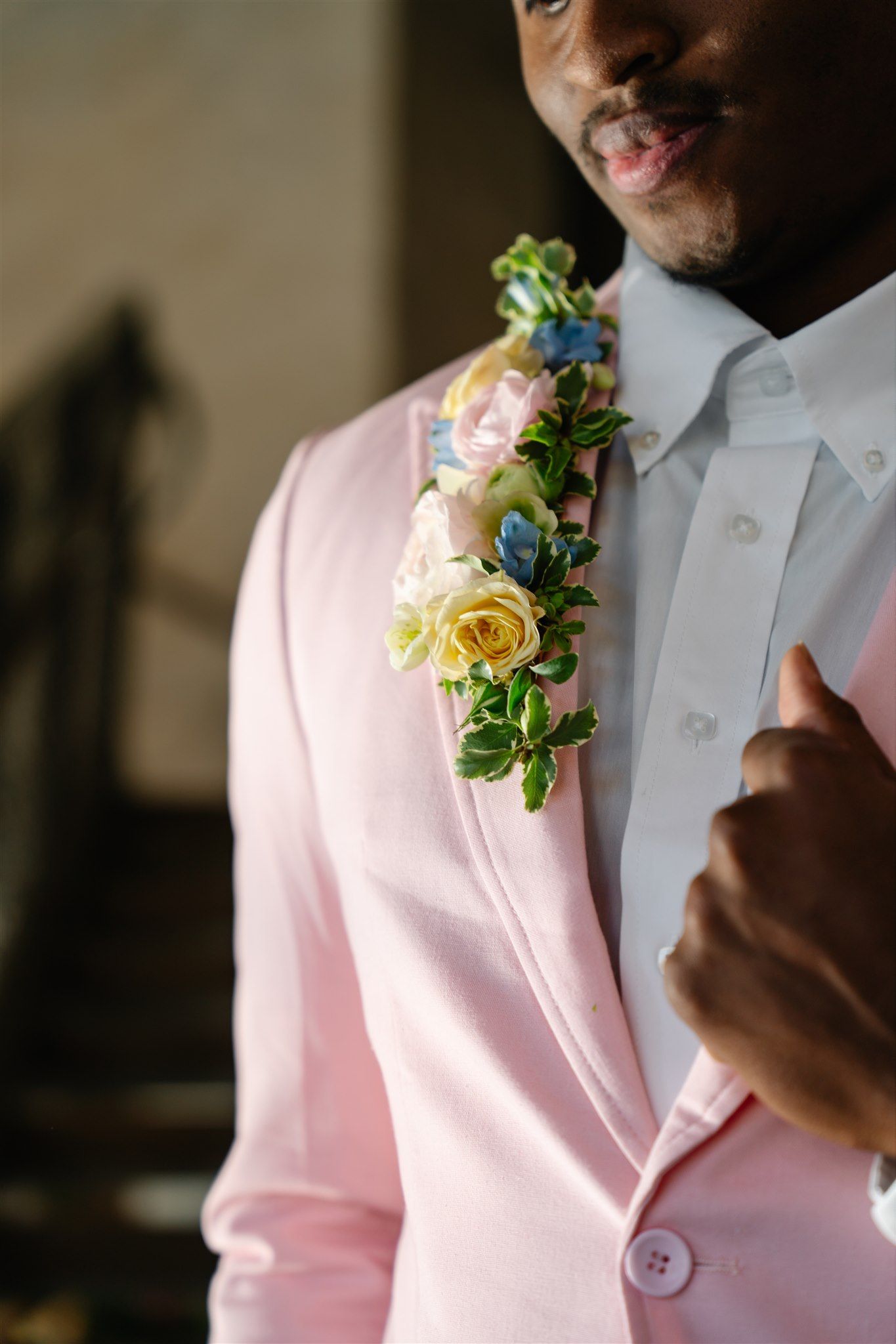 Close-up of groom in light pink suit with colorful floral boutonniere — stylish wedding detail in Salt Lake City