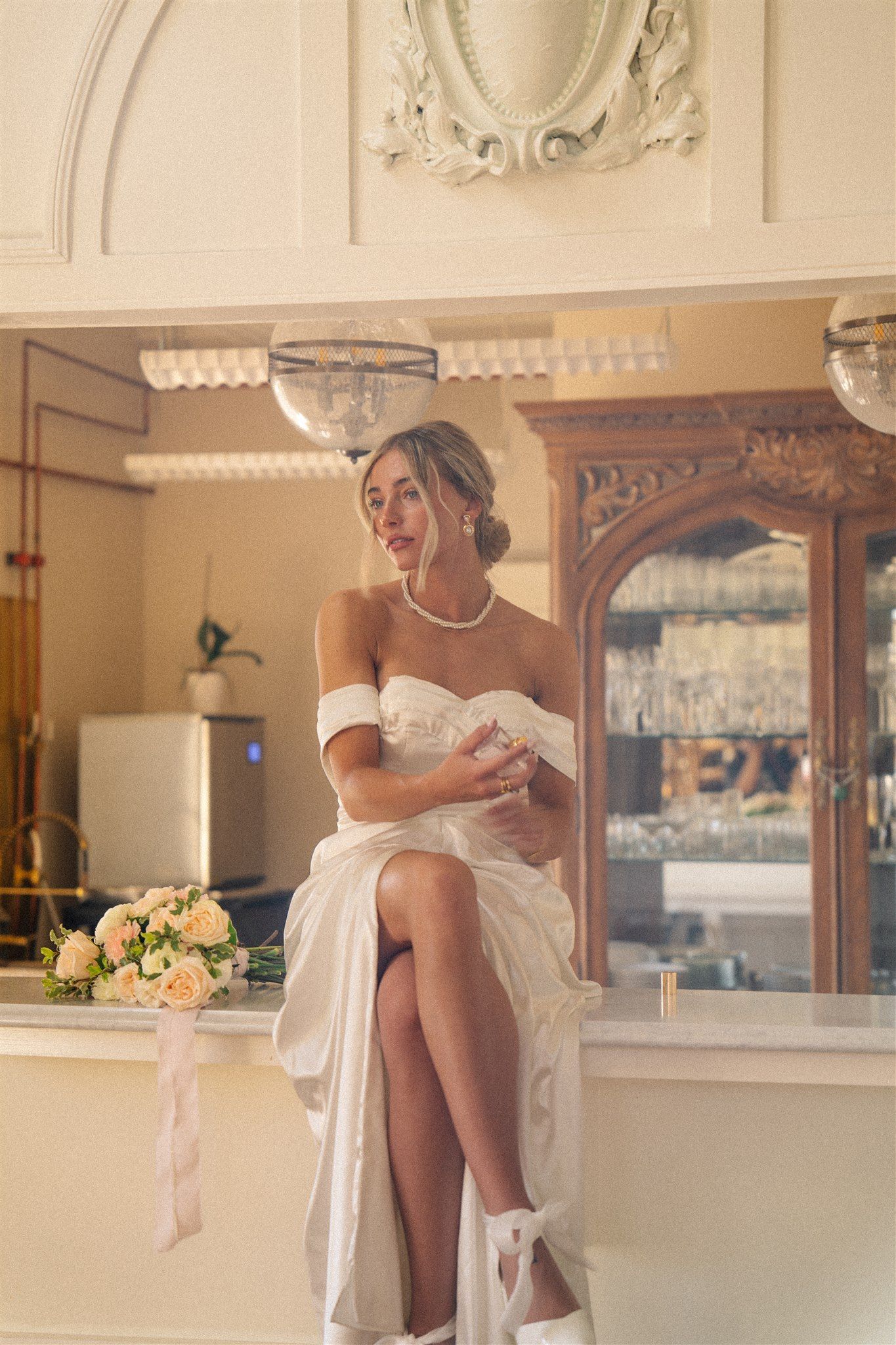 Artistic bridal portrait showing white dress and shoes in vintage-style setting.