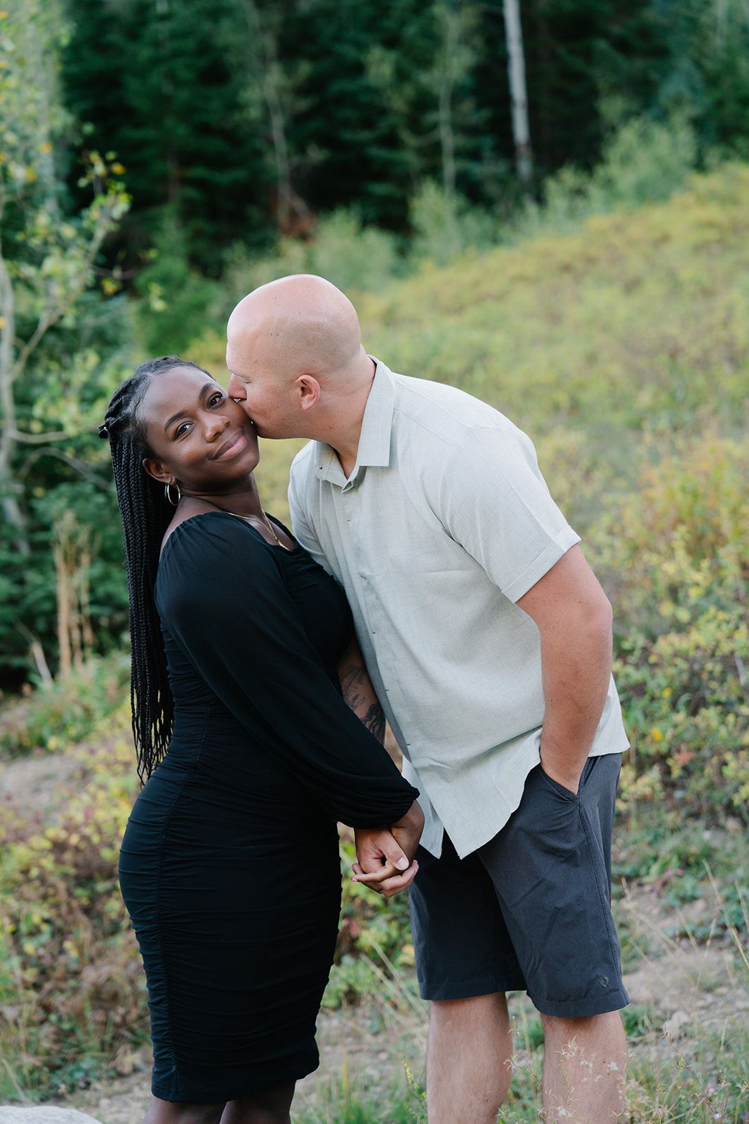 Playful couple poses and interactions captured in a mountain setting.
