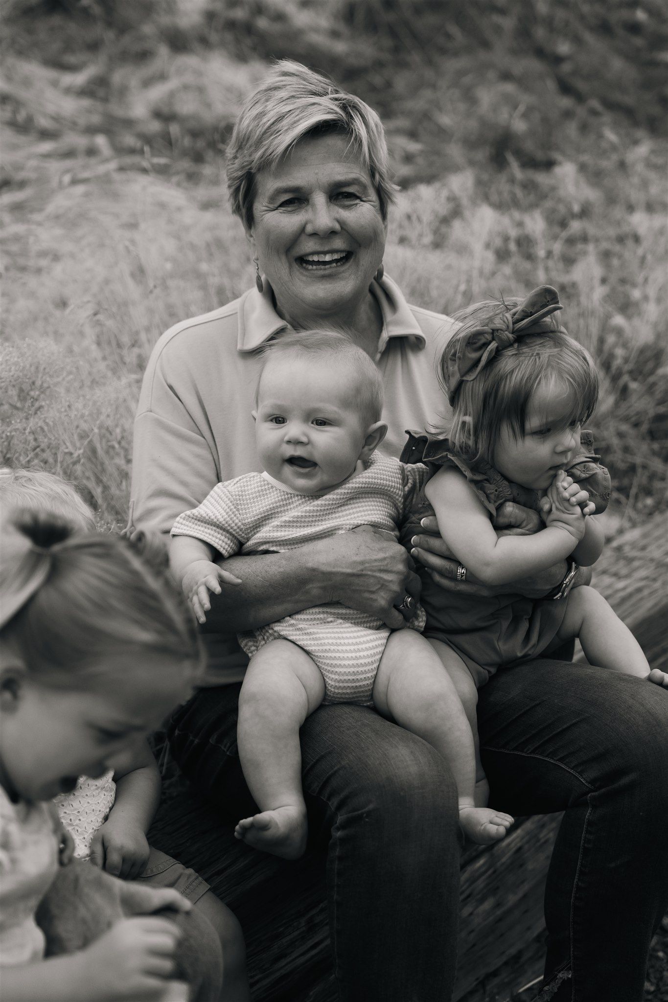 Candid black and white photo capturing playful family interactions outdoors.