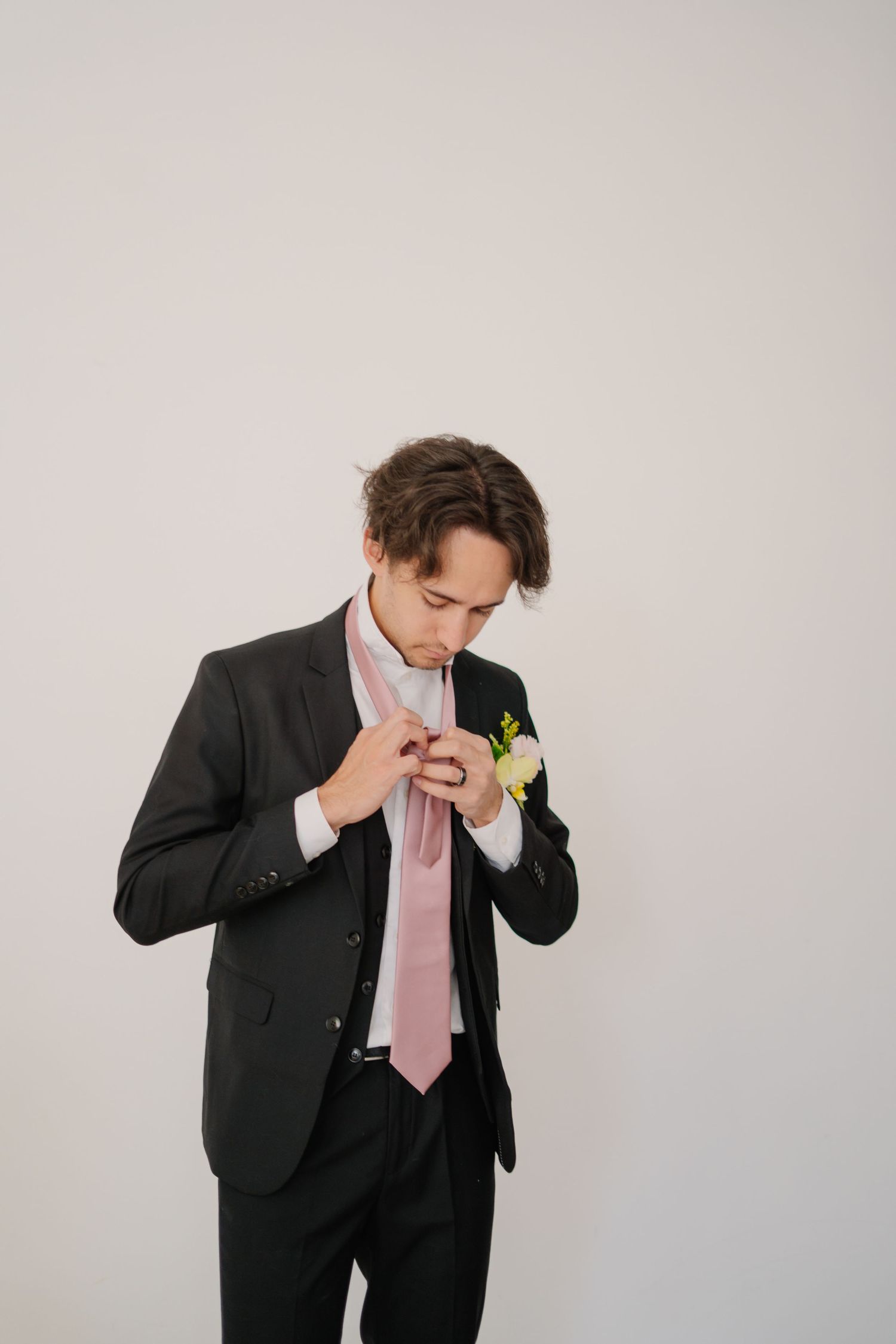 Groom in dark suit and pink tie showing emotional reaction in wedding photo sequence.