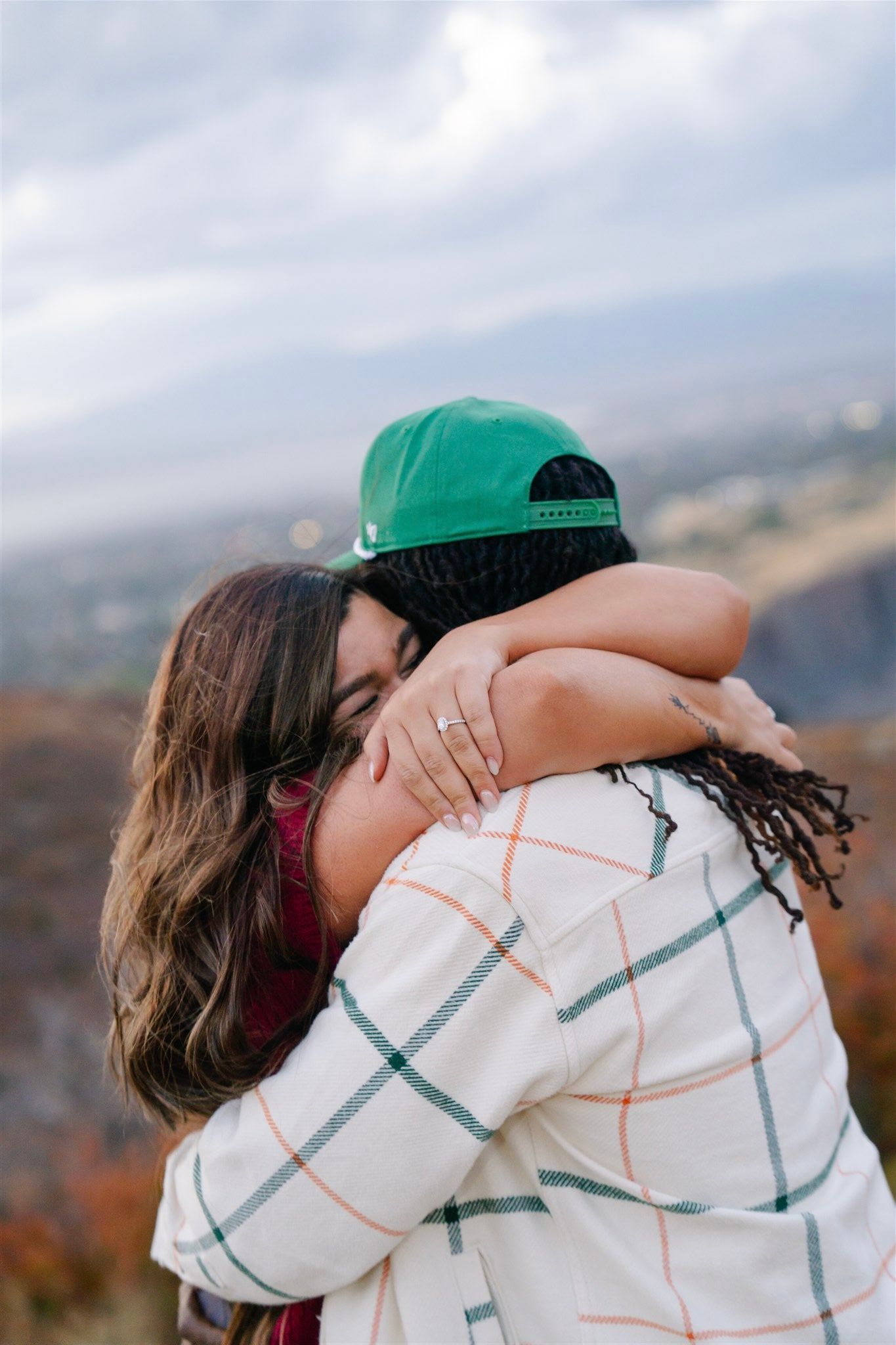 Close up of couple embracing while wearing casual sweaters outdoors.