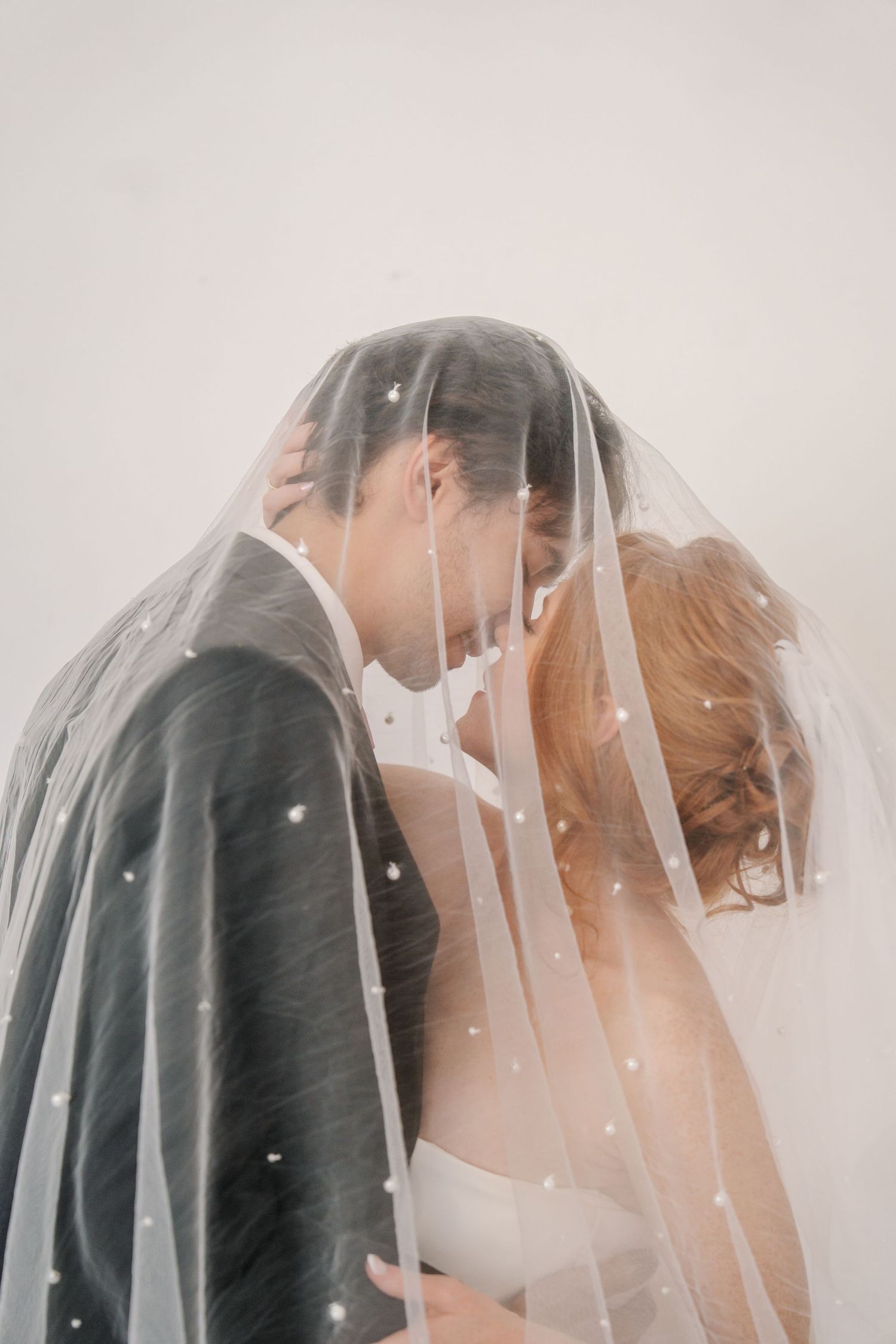 Romantic wedding portrait sequence of couple sharing intimate moment under delicate veil.