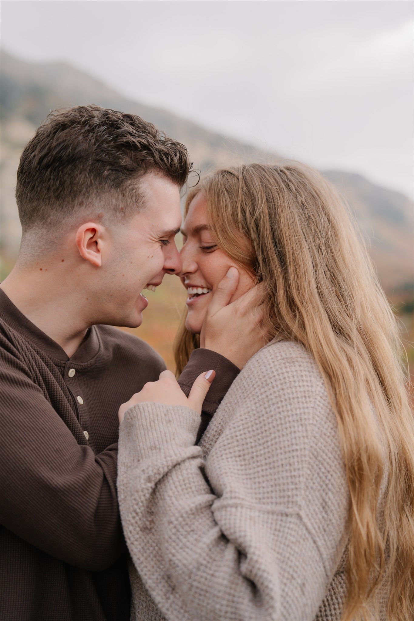 Engaged couple embracing and laughing during golden hour – Utah couples photographer.