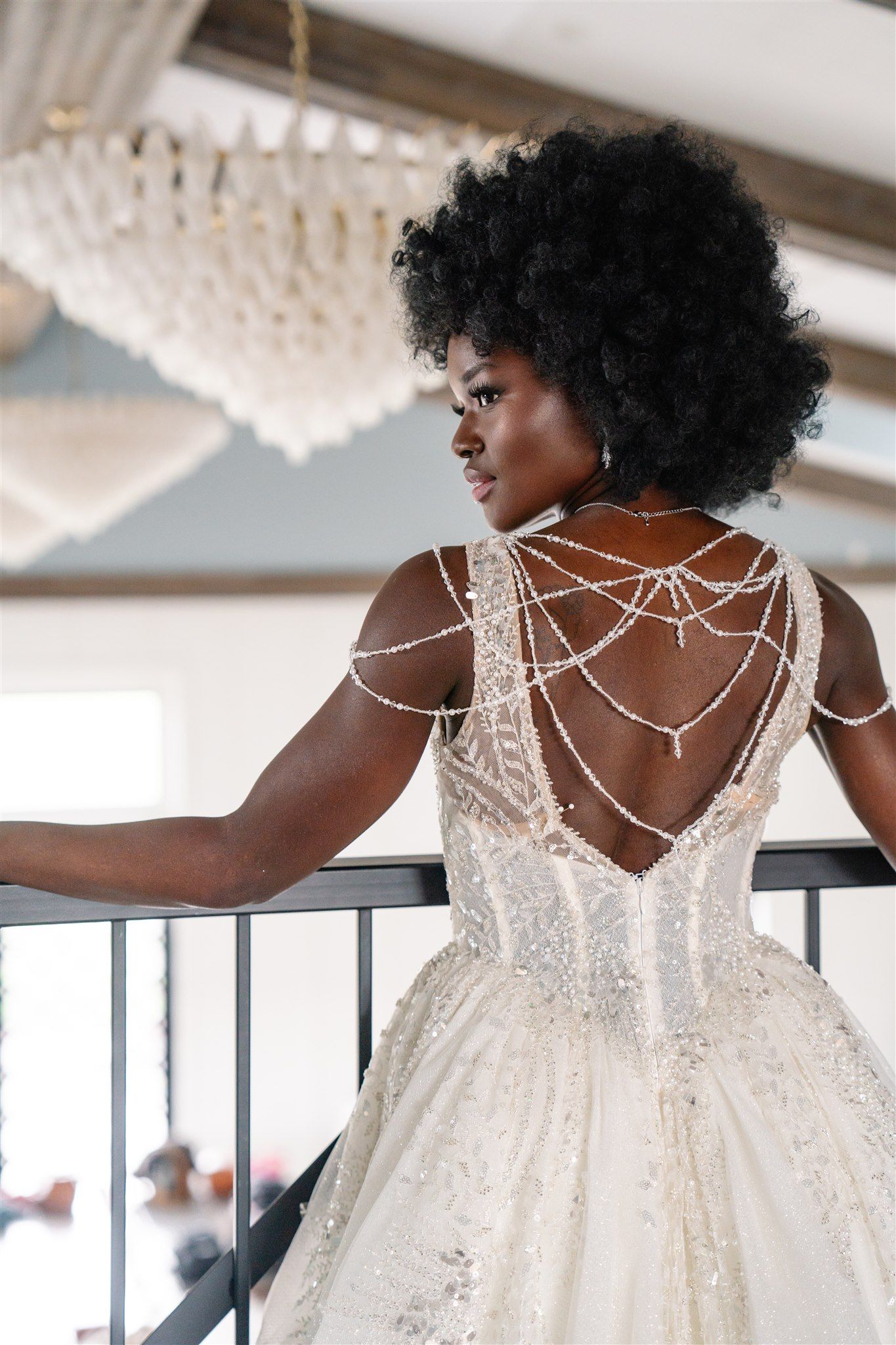 Back view of an elegant white wedding dress with intricate strappy lace detail.