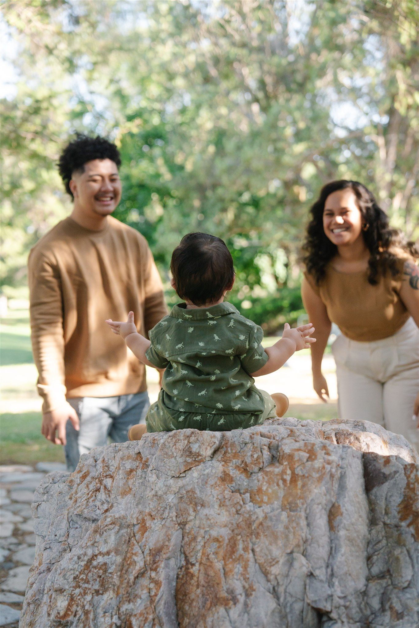 Family sharing joyful moments together on stone wall in outdoor setting.