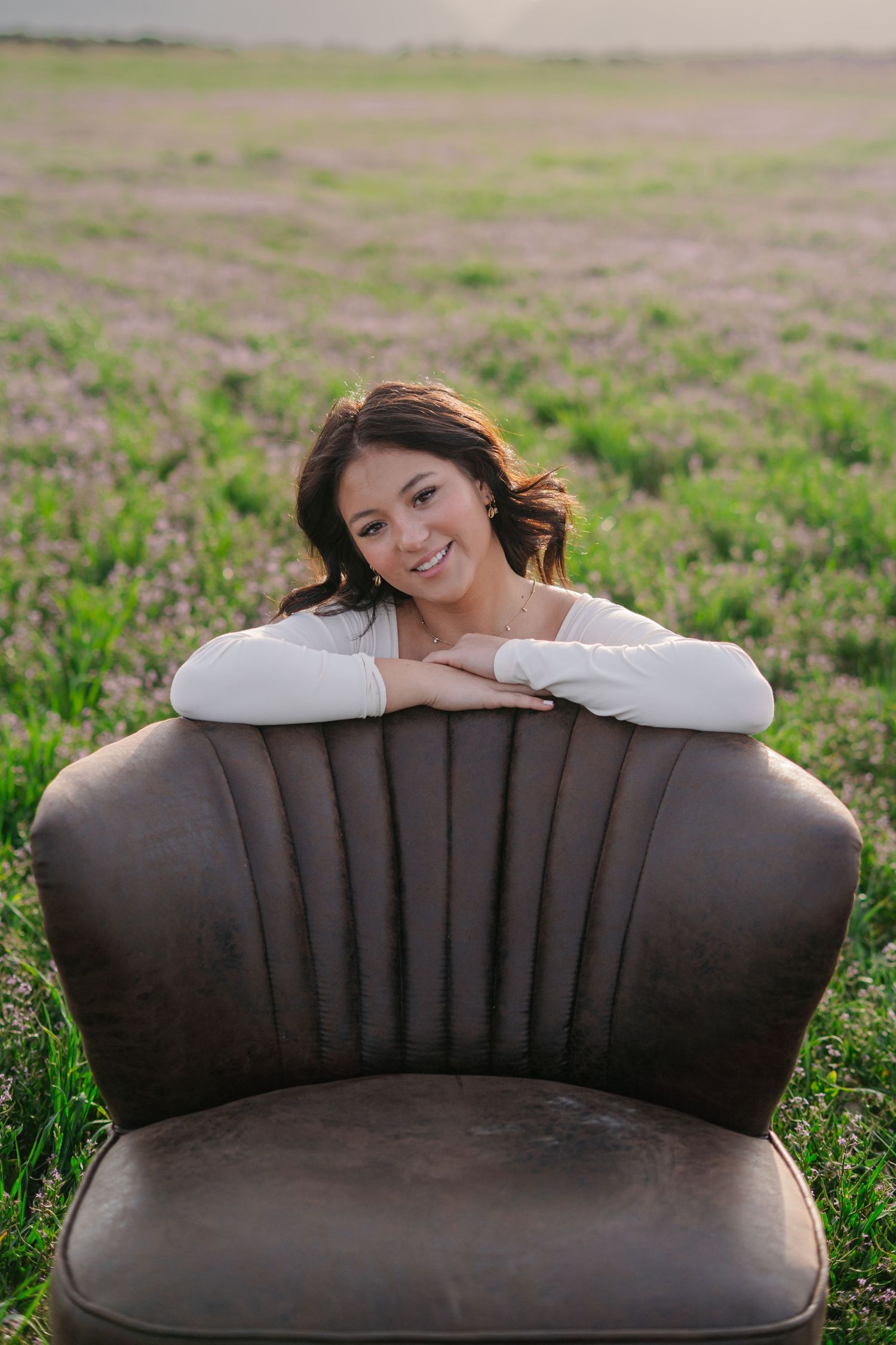 Vintage brown sofa placed in a blooming wildflower field.