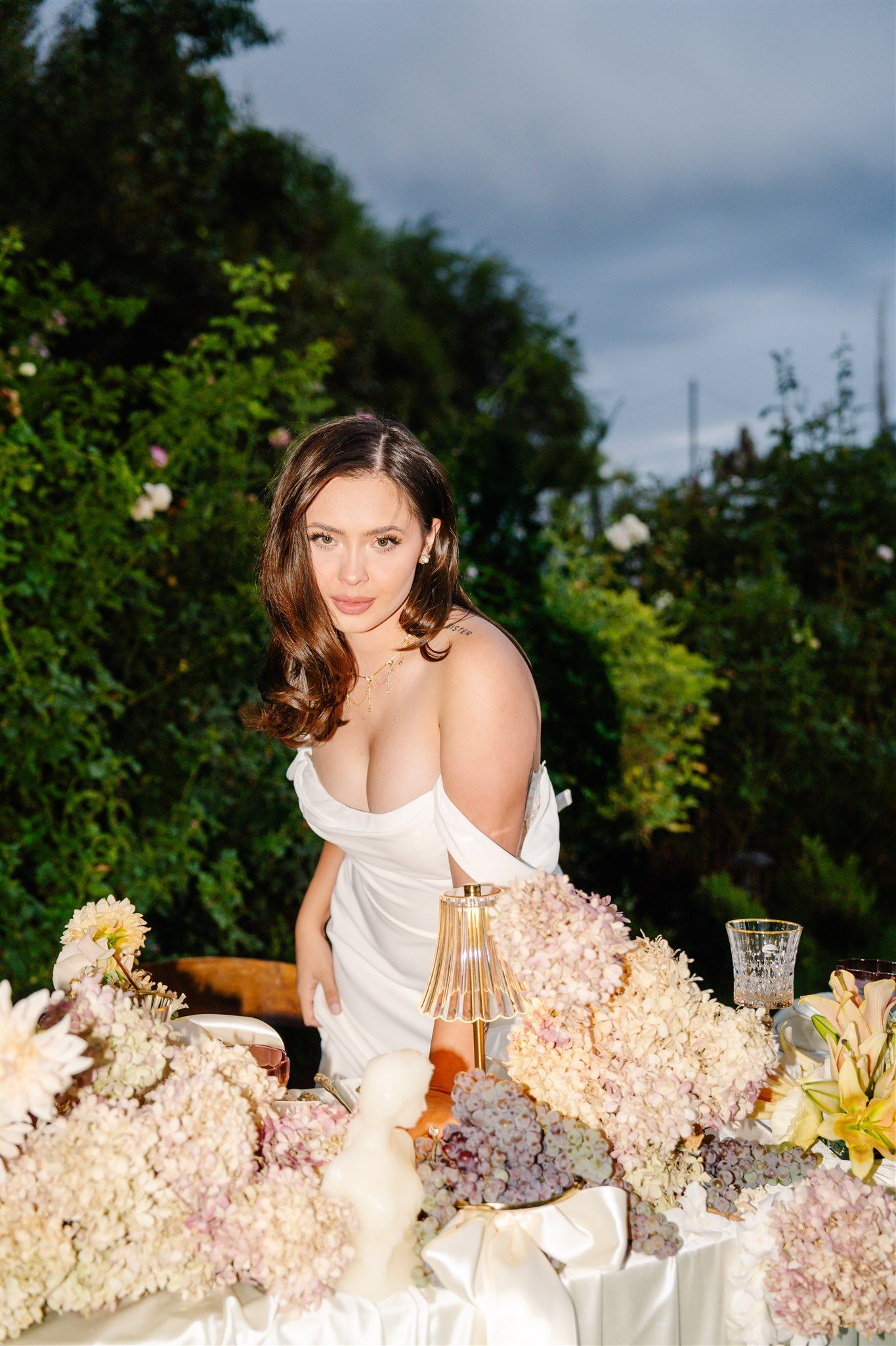 An elegant table setting with pastel hydrangeas and decorative elements in an outdoor garden setting.
