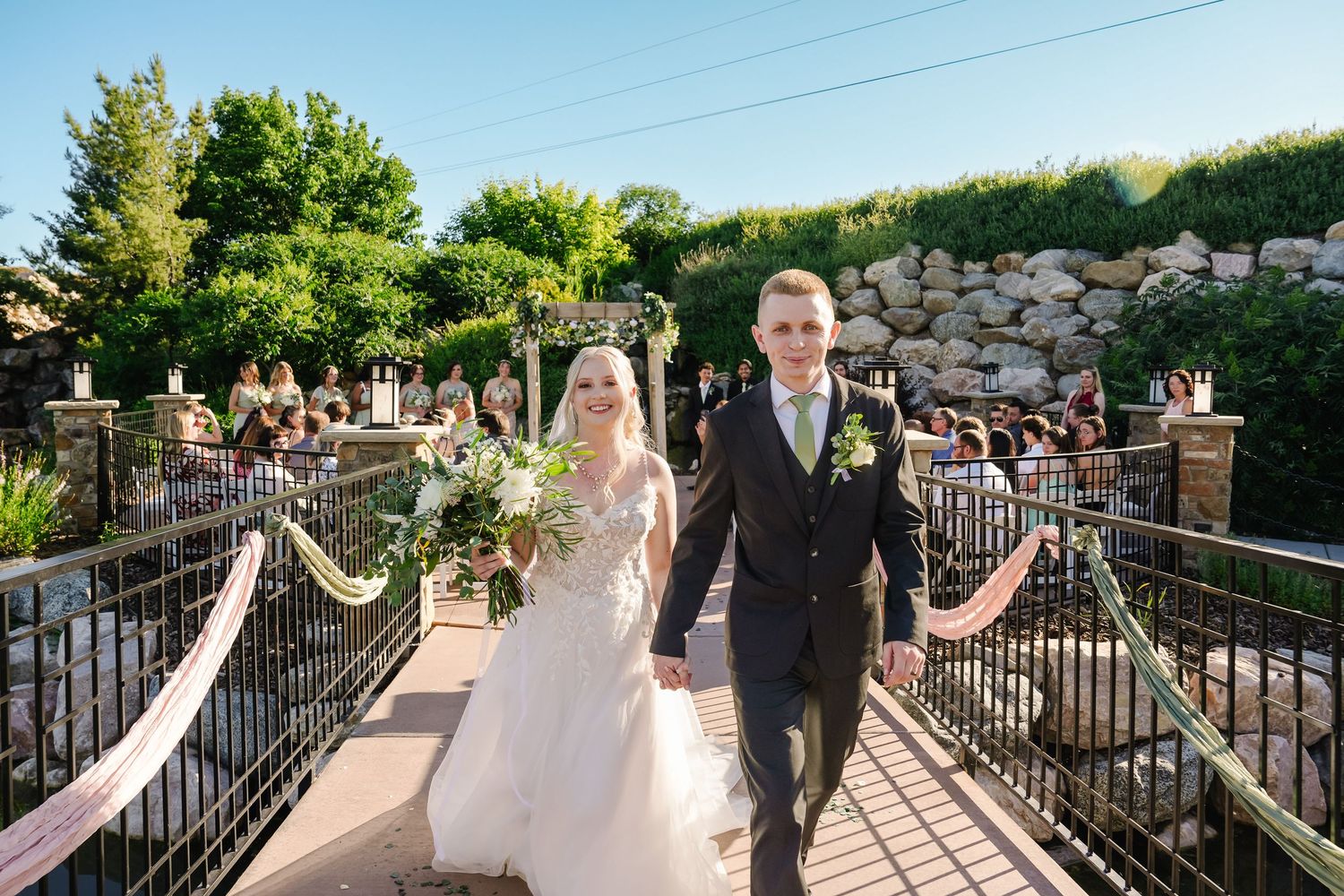 Wedding party walks along a stone path with scenic mountain views in the background.