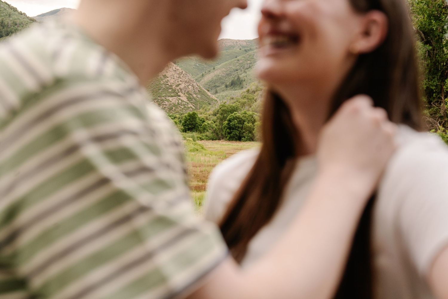Close-up shot of two people sharing an intimate moment outdoors.
