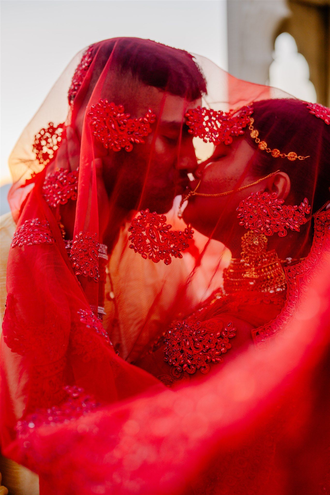 Abstract close-up of red fabric with sparkling details in dramatic lighting.