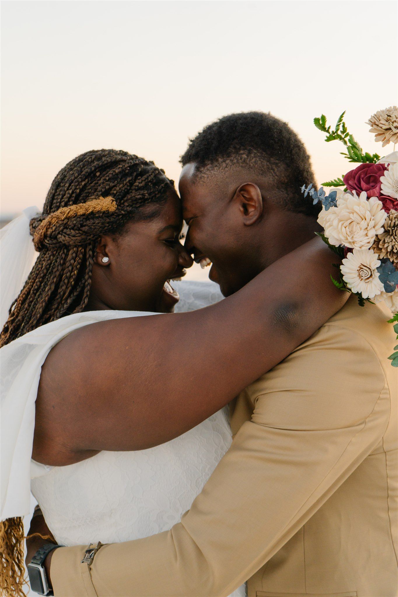 Intimate wedding portrait with floral details against soft natural lighting.