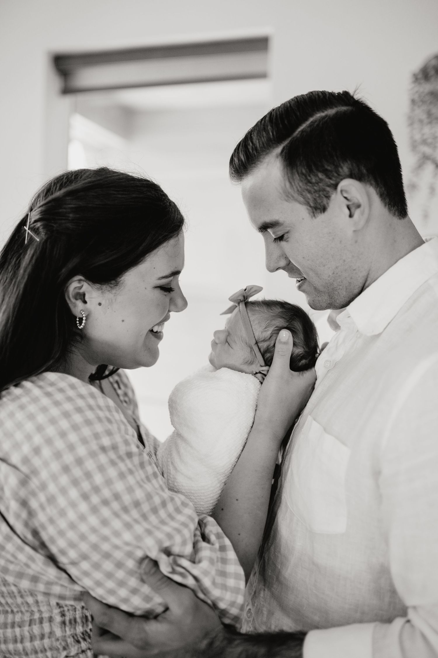 Mom and Dad looking at their newborn during their in-home lifestyle newborn session