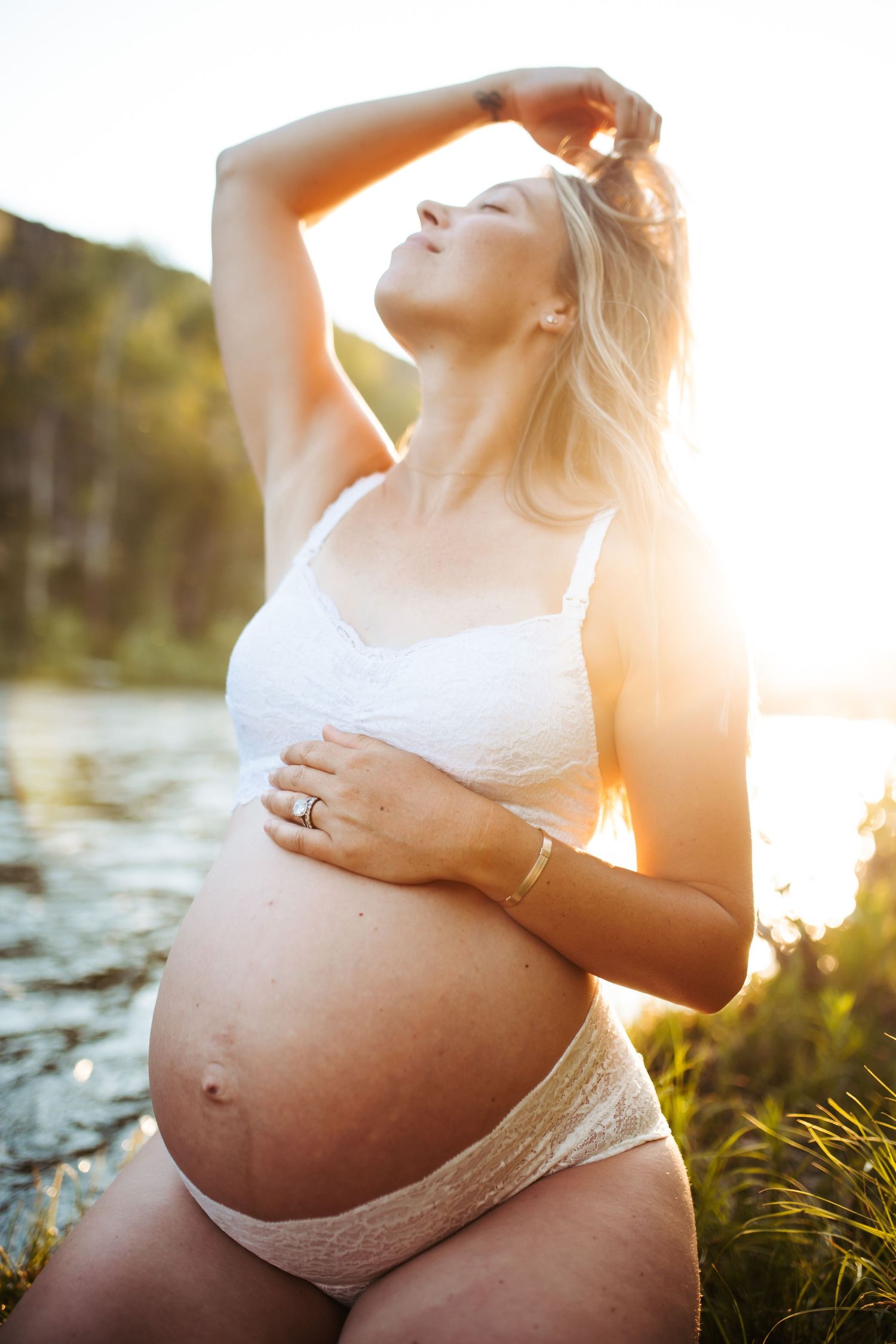 Young woman poses for maternity photoshoot in Boise along the river