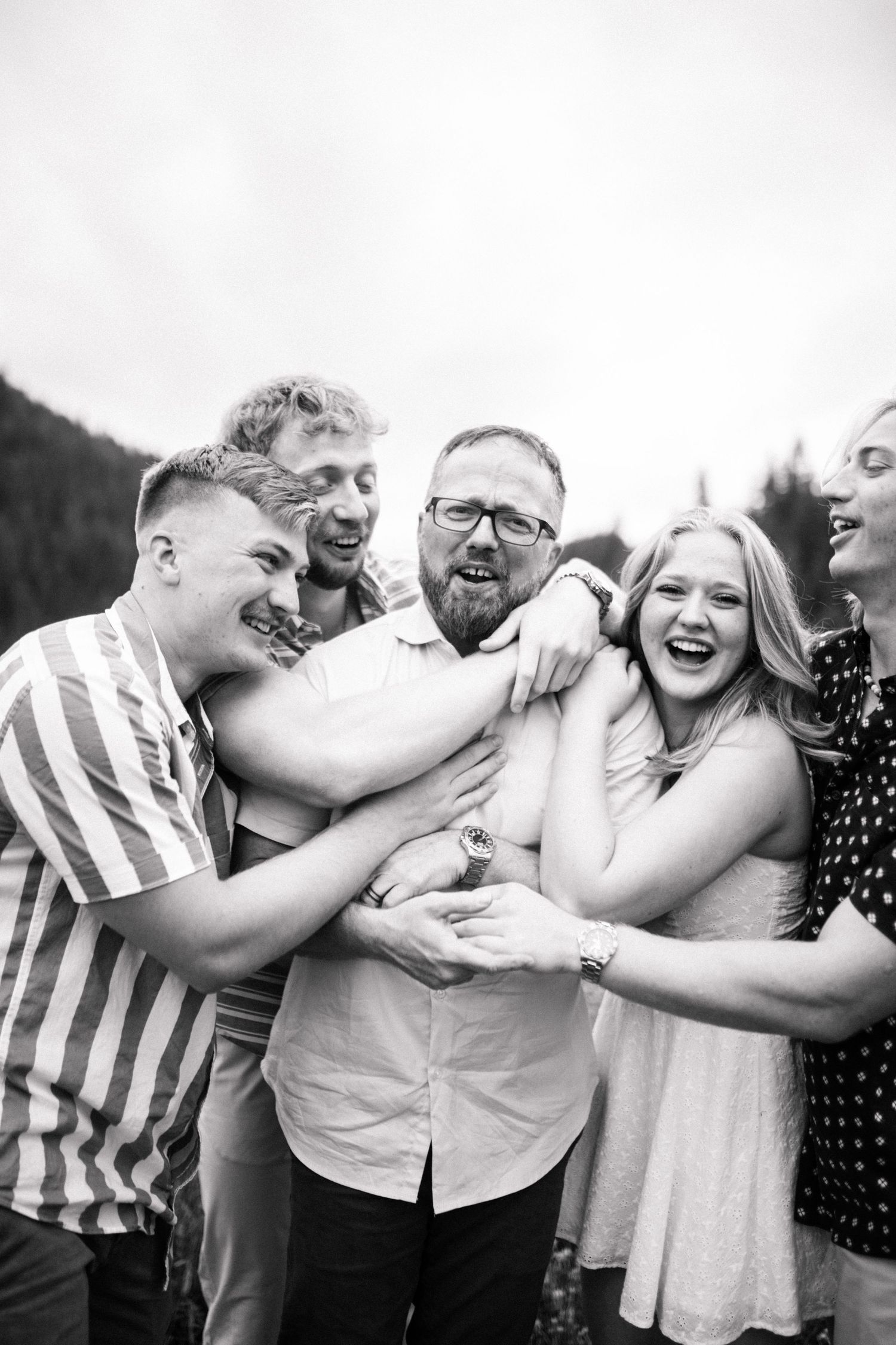 Dad and his older children laughing for a portrait together