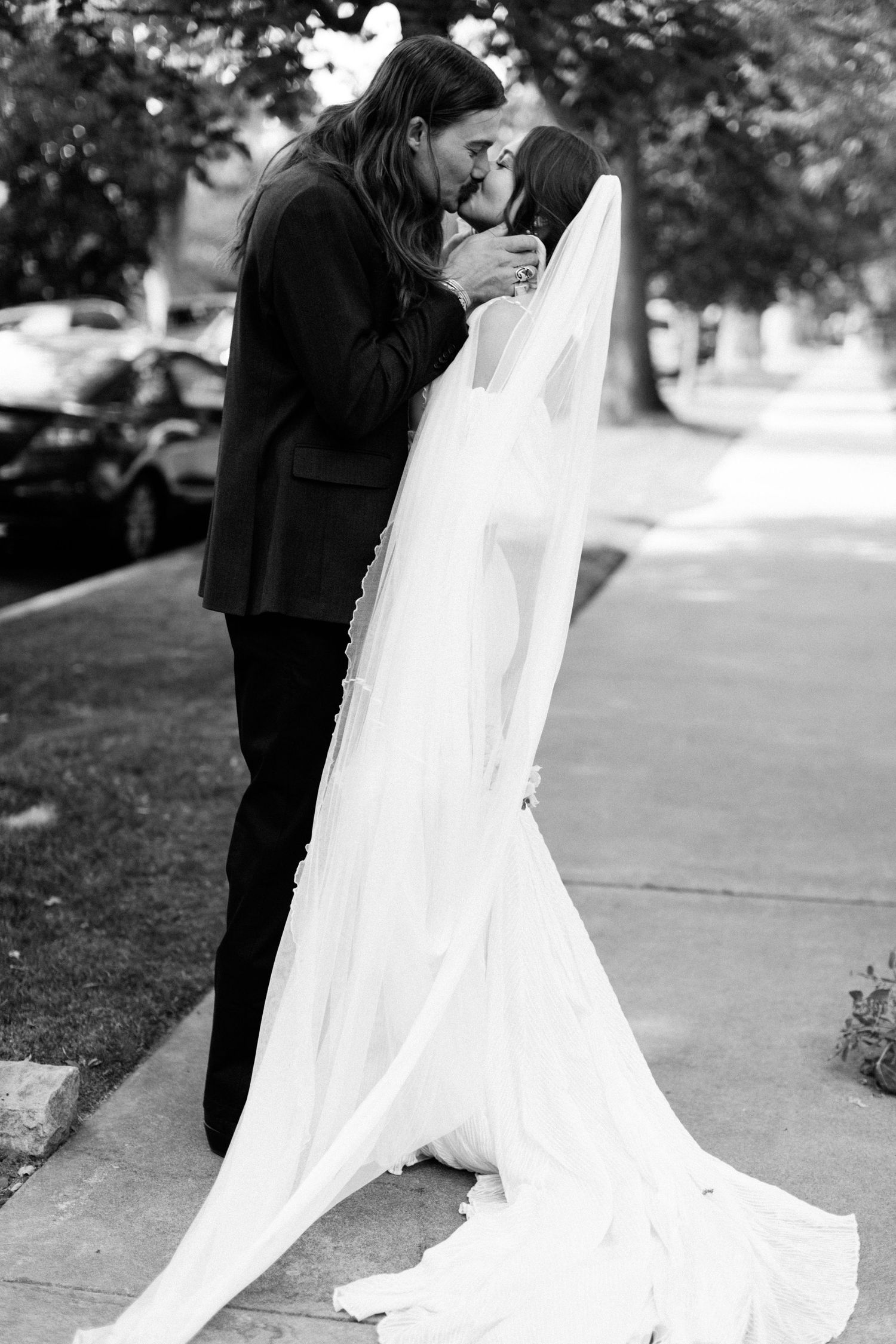 Newlyweds kissing eachother in black and white