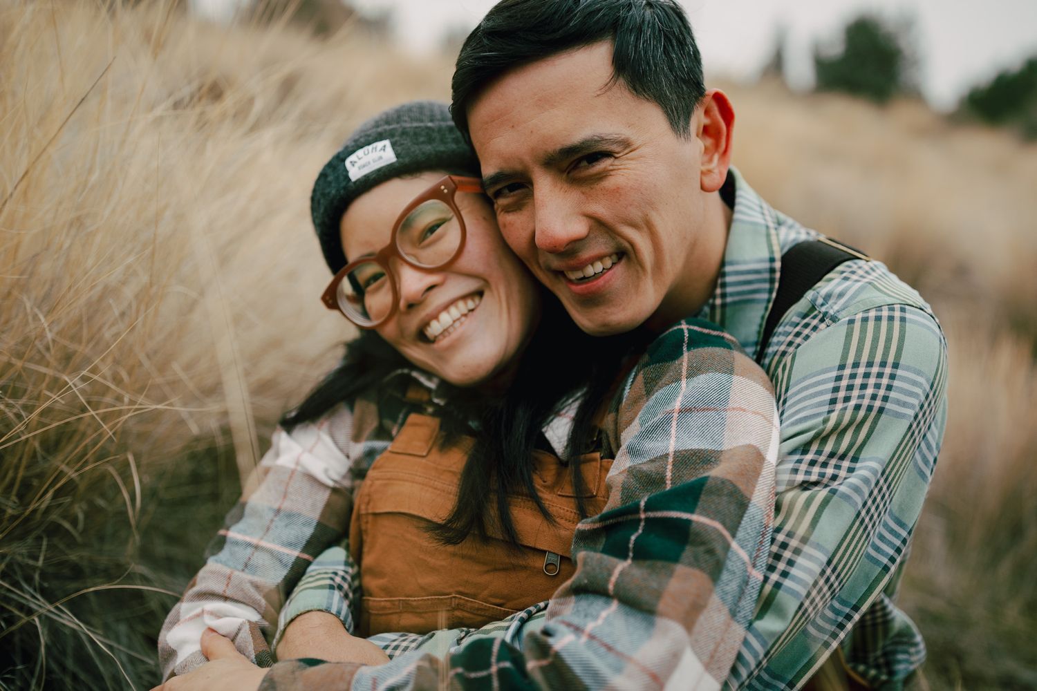 Couple sitting & smiling together closely for a photoshoot in Redmond Oregon