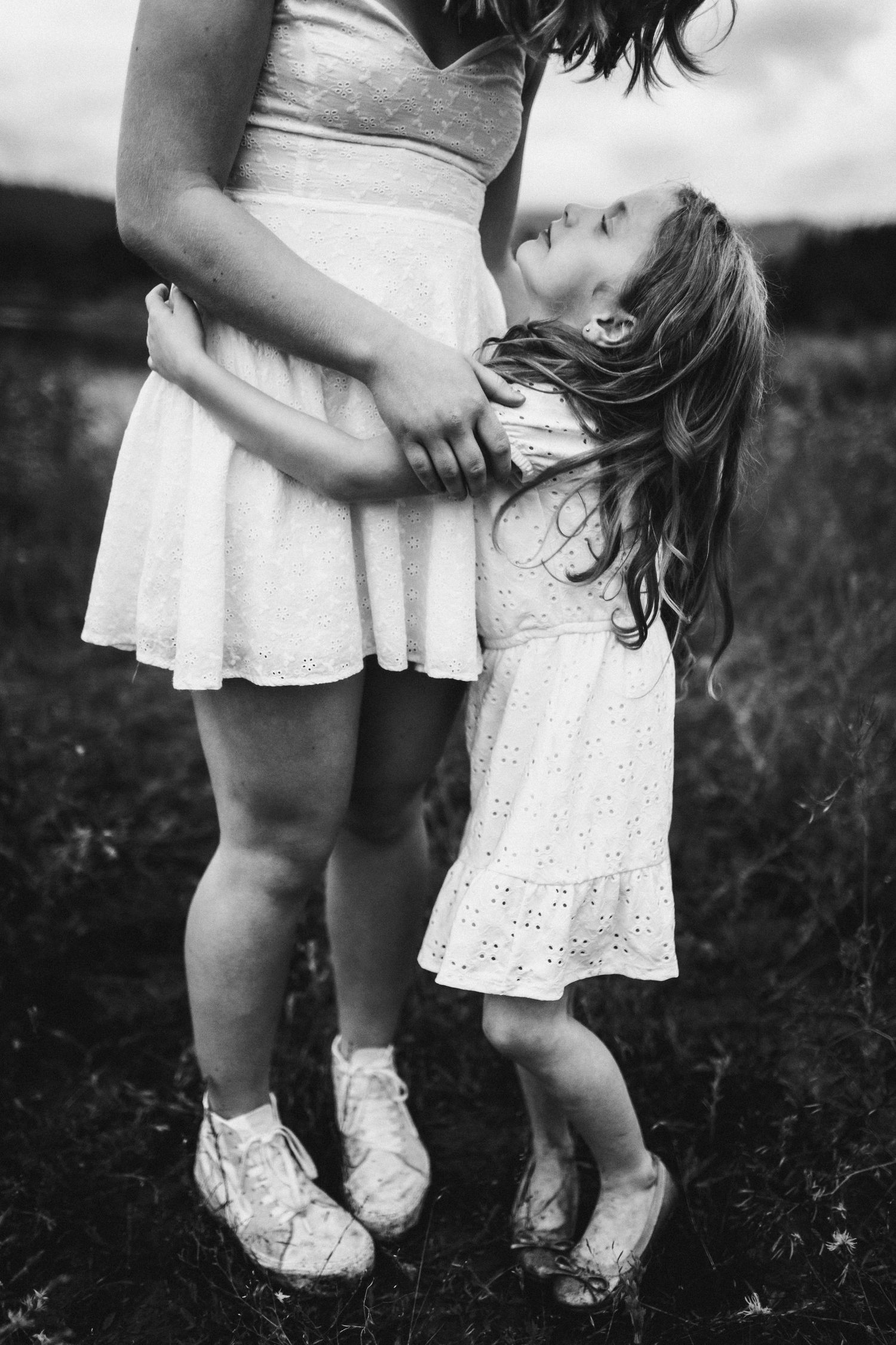 Little sister looks up at big sister for a portrait
