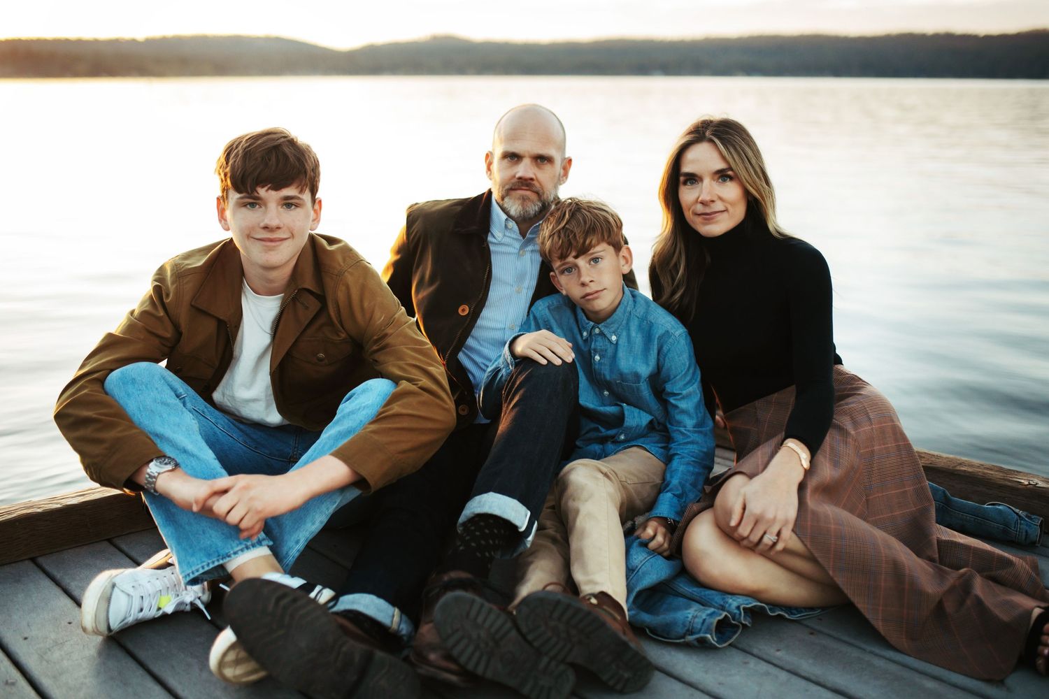 Family sitting together on a dock for a photoshoot in McCall Idaho