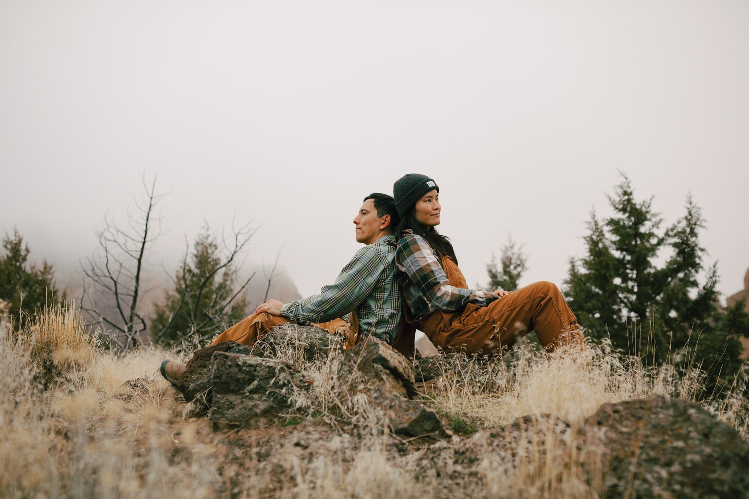 couple sitting backs against eachother admiring nature
