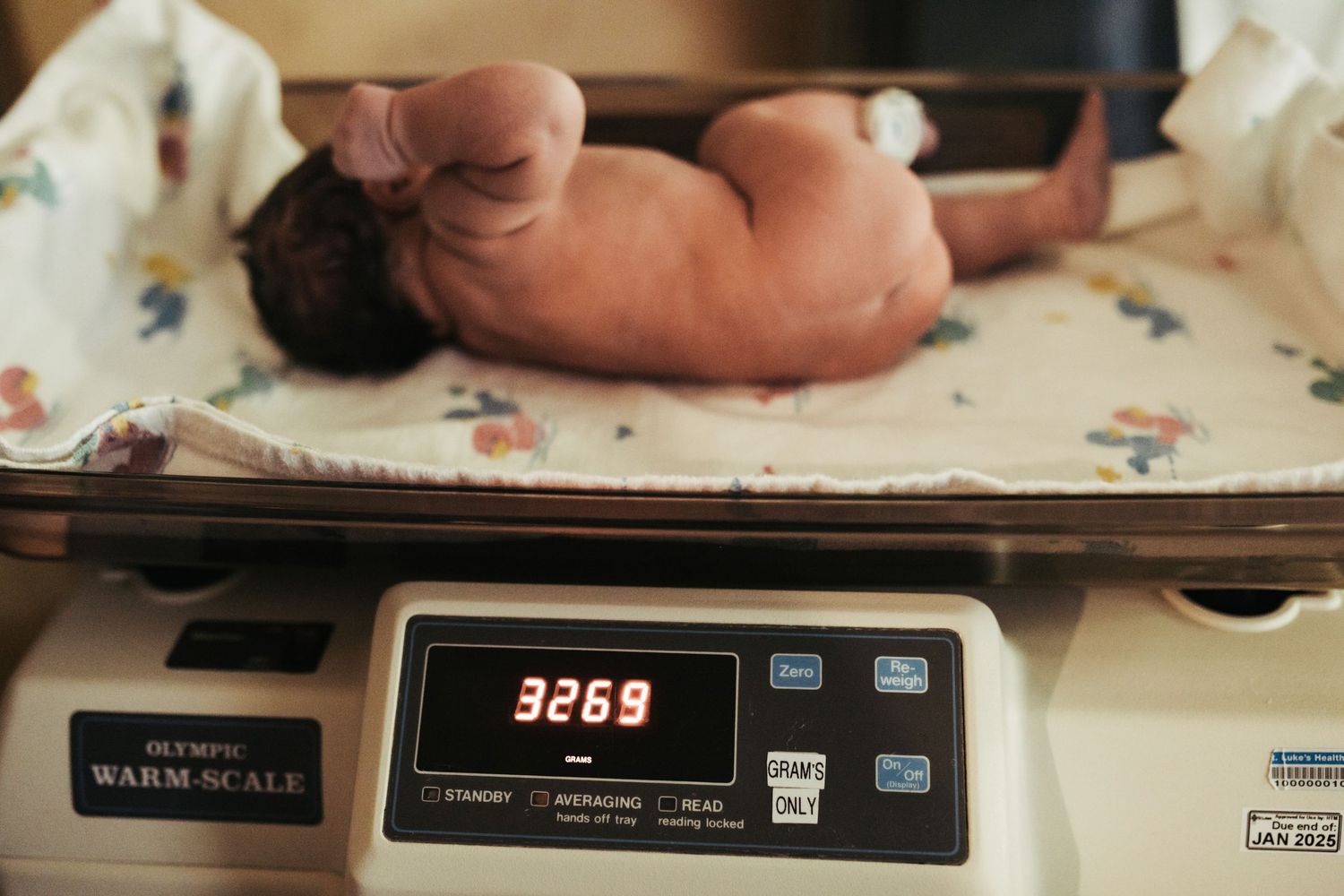 Photograph of a newborn baby being weighed in Boise