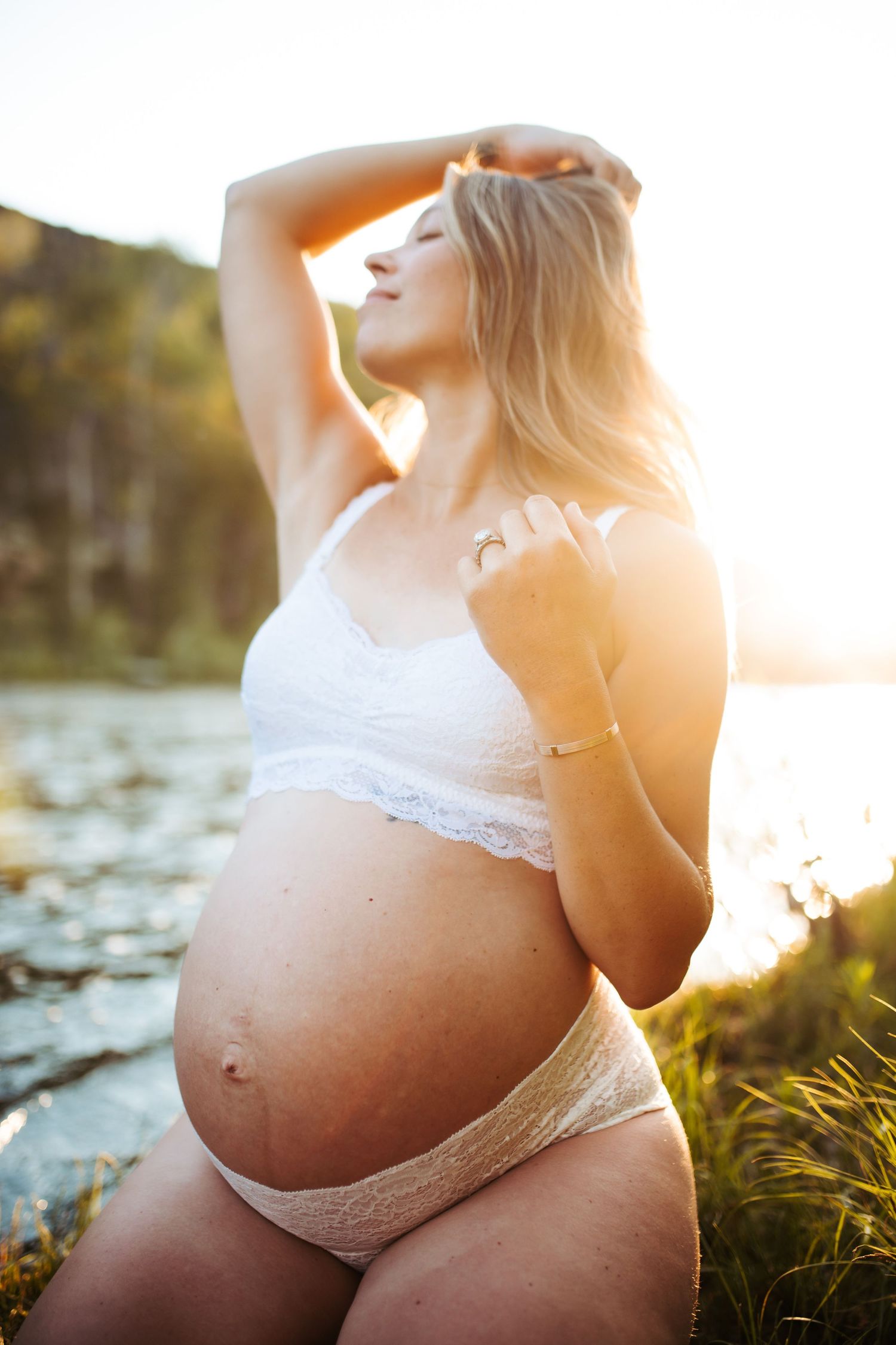 Young woman poses for maternity photoshoot in Boise along the river