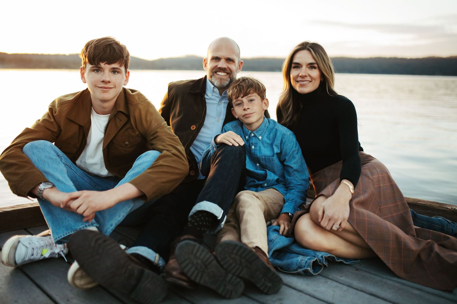 Family sitting together on a dock for a photoshoot in McCall Idaho