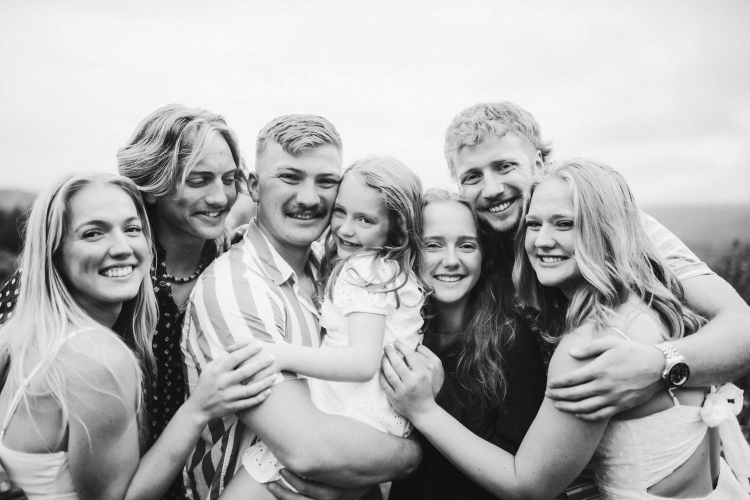 Siblings huddled together for a portrait in black and white