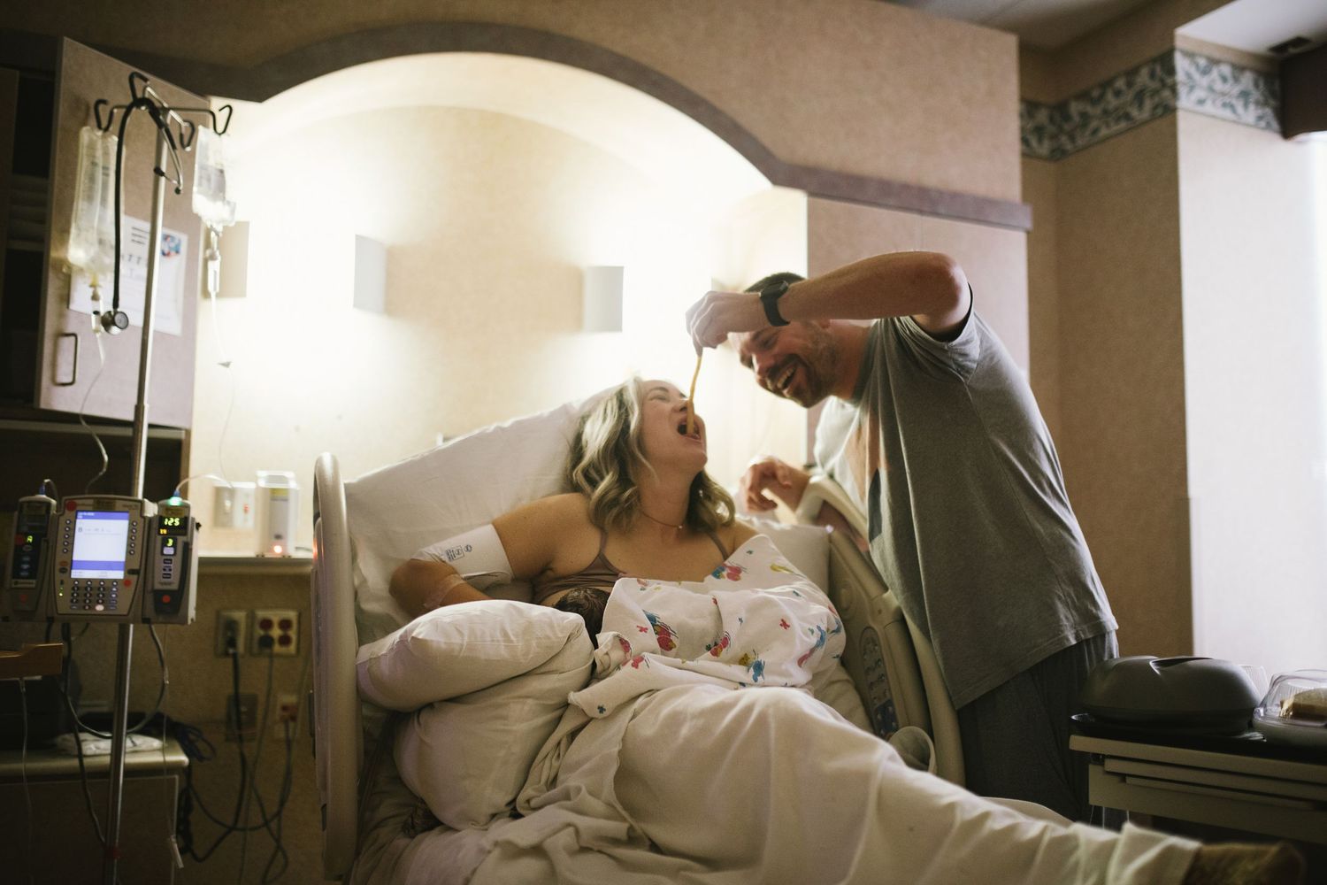 Photograph of dad feeding his wife after she had their new baby in Boise Idaho