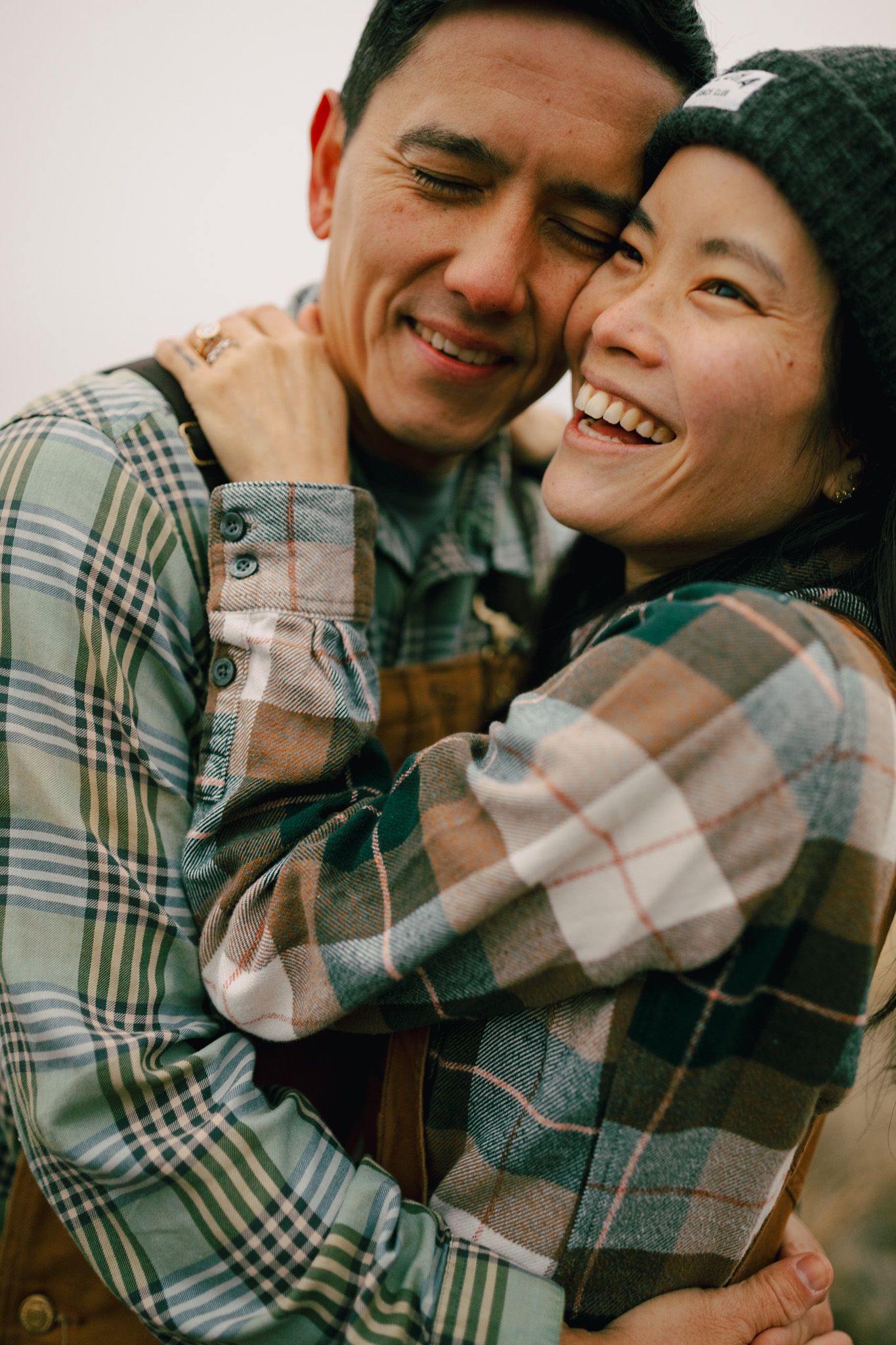 Couple standing together laughing playfully for photoshoot