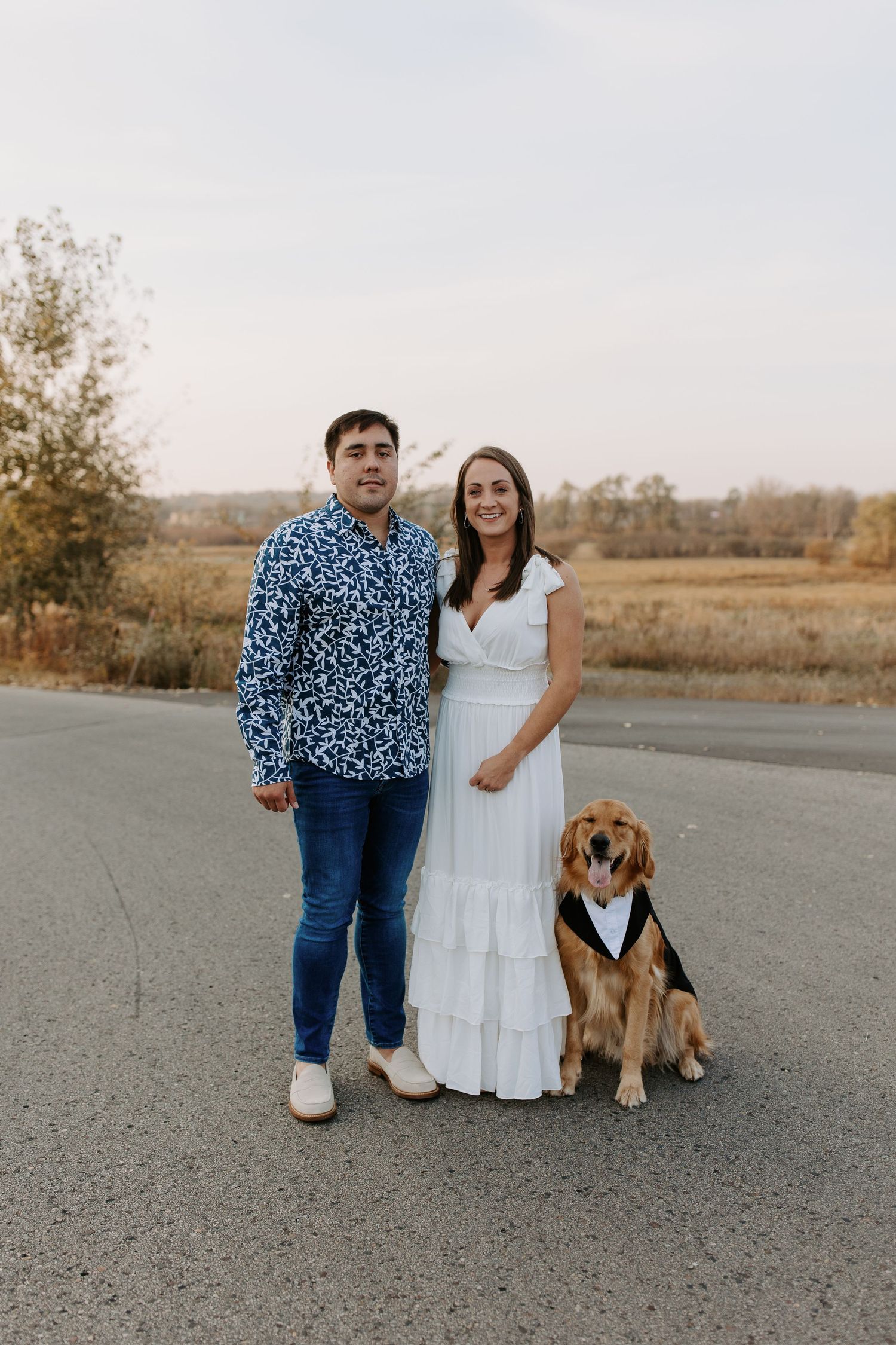 Outdoor portrait session with a couple and their beagle dog on a rural road.