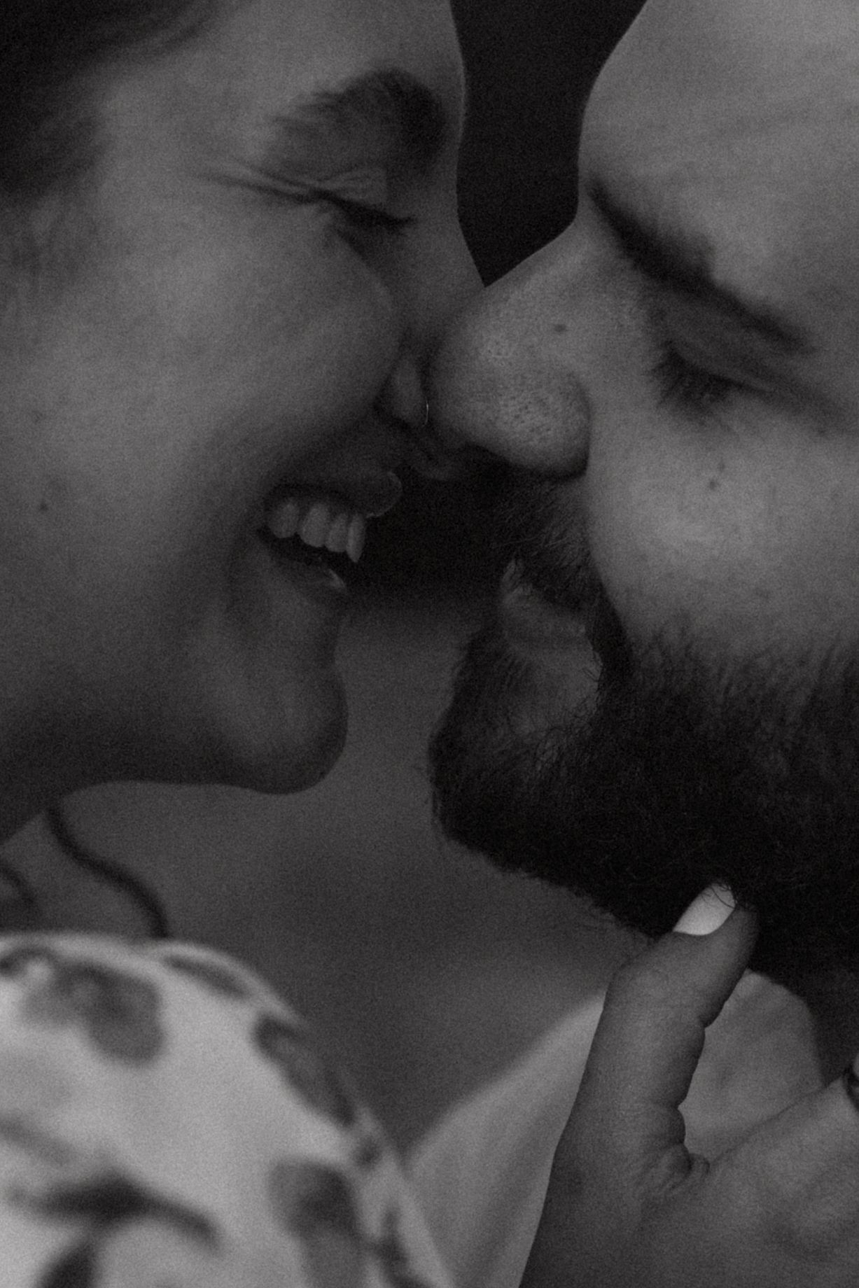 Intimate close-up black and white portrait of a couple sharing a tender moment.