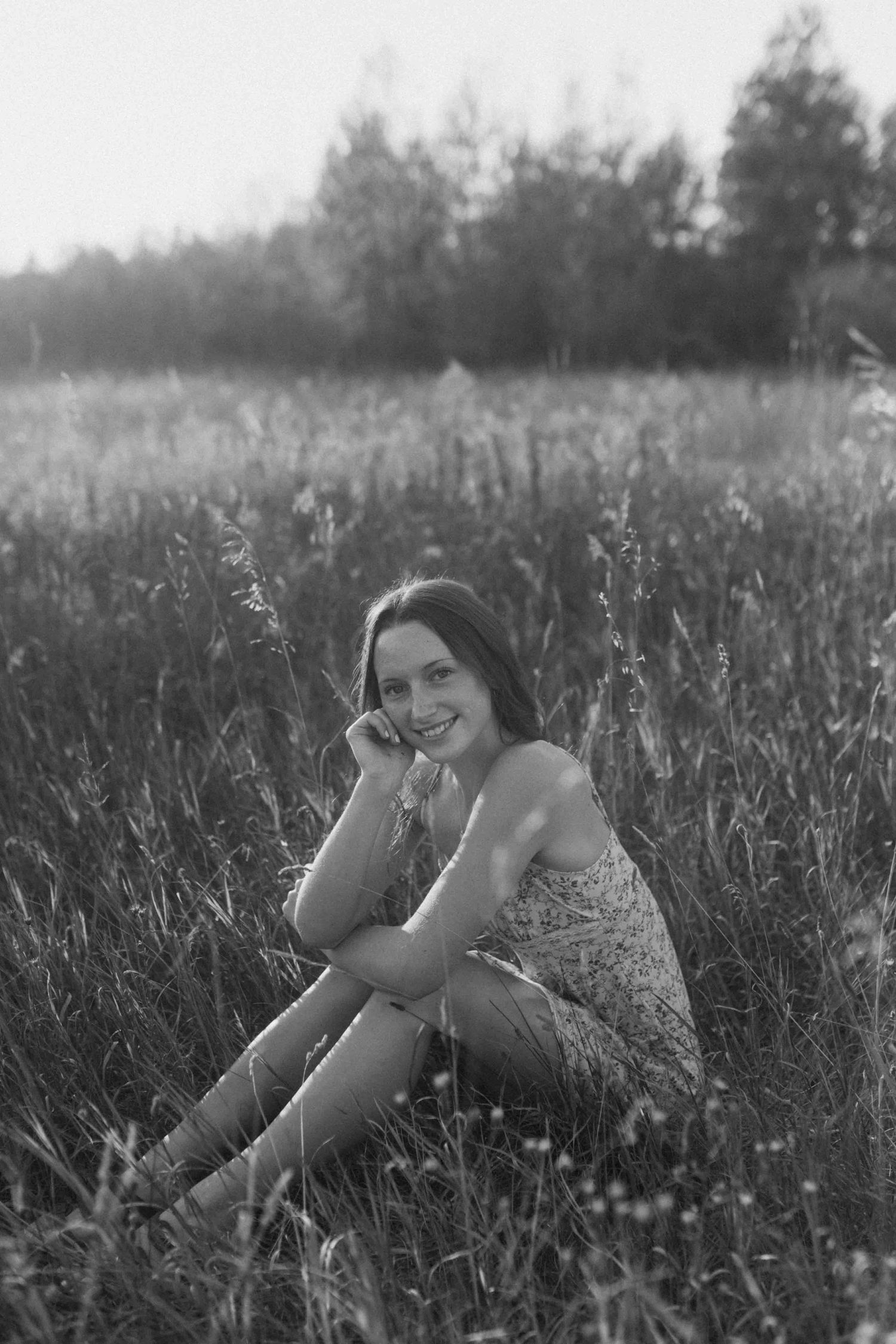 Monochrome image of someone posing playfully in a summer field.