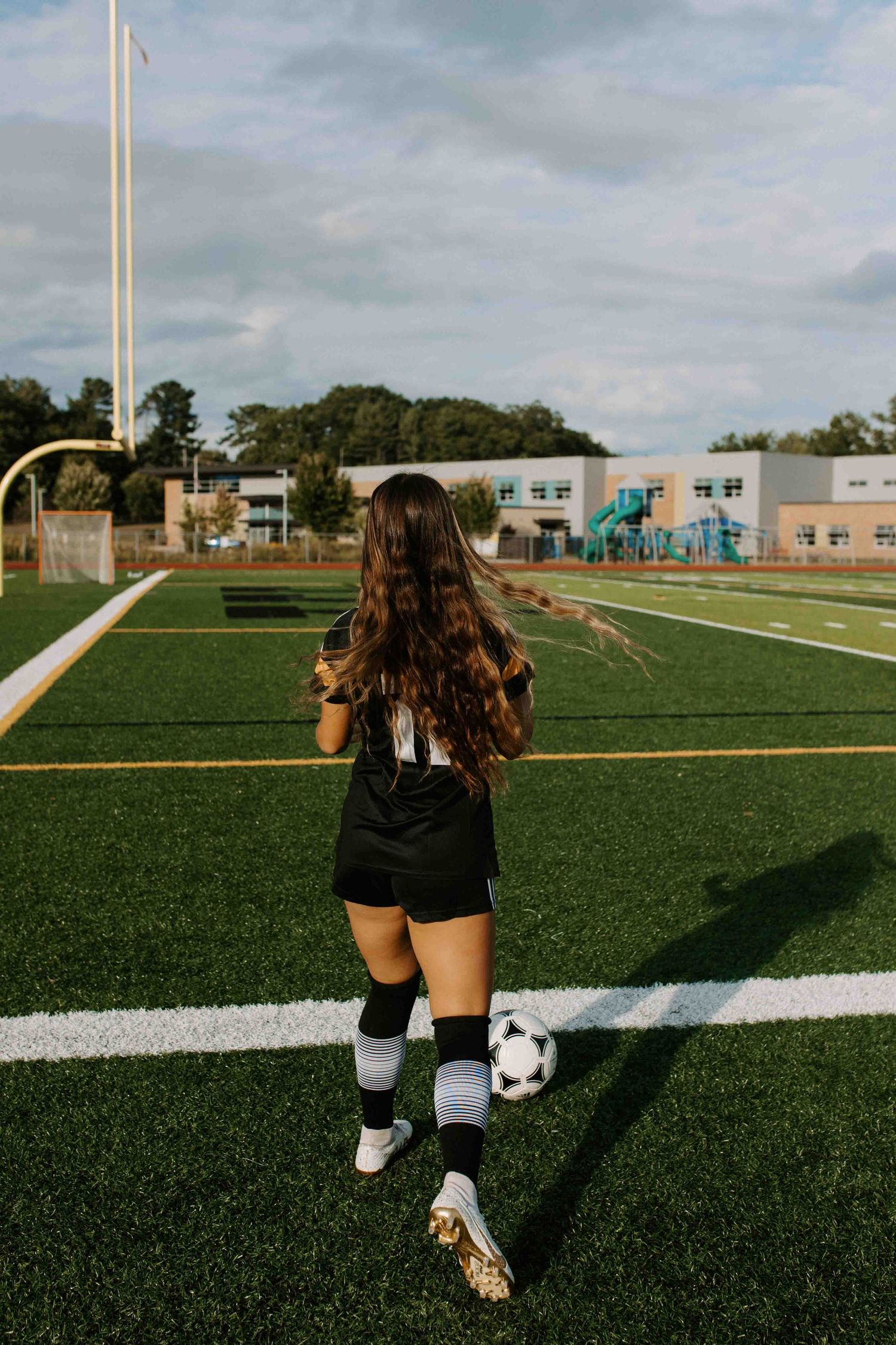 Soccer player practicing ball control drills on artificial turf field.